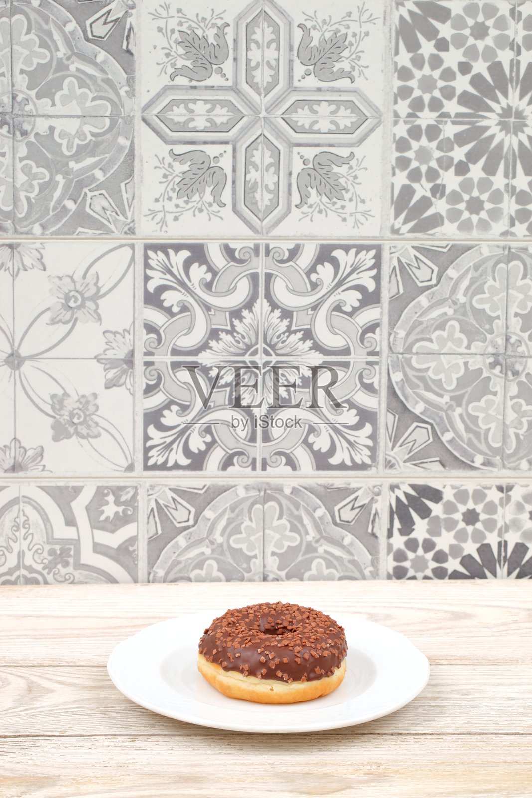 奢华美味的巧克力甜甜圈优雅地摆放在美丽的图案背景上照片摄影图片