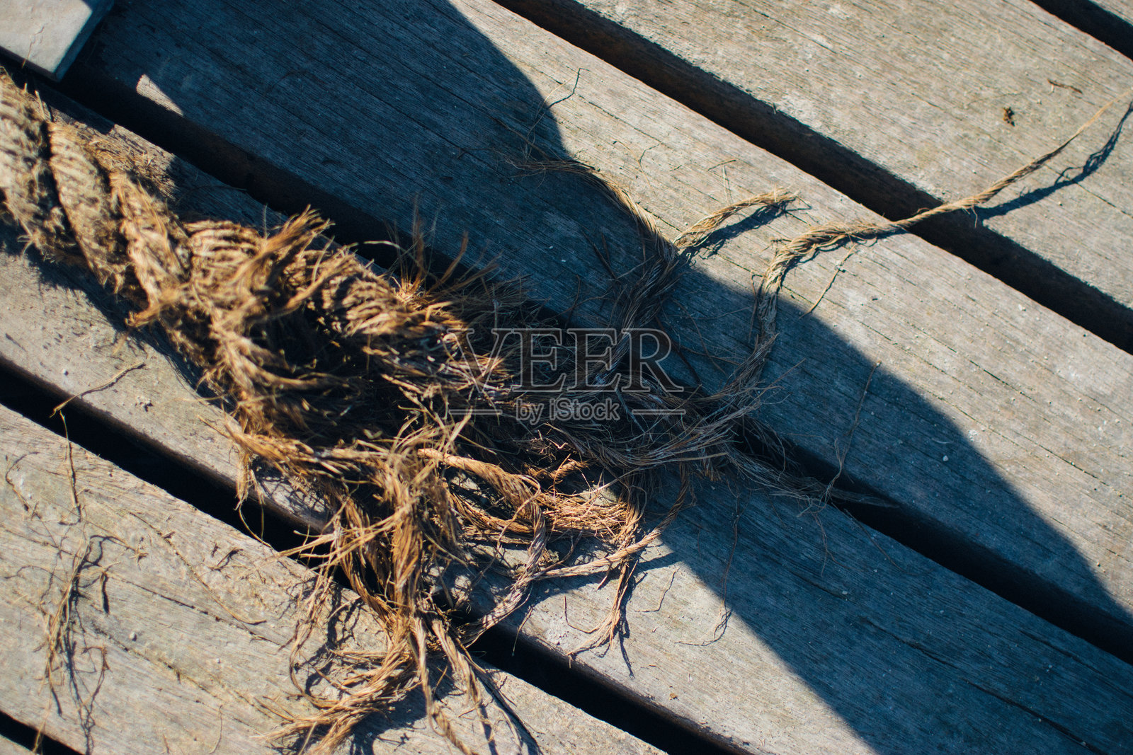 在风化的木板上松散的绳索尖端照片摄影图片
