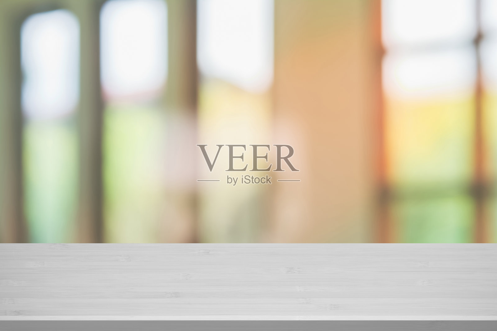 木质桌子与抽象模糊的咖啡店或咖啡馆室内背景。餐厅室内横幅，医院和诊所模糊。户外绿色模糊窗户和明亮客厅的景观。照片摄影图片