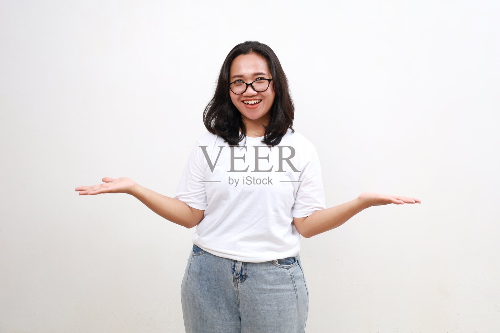 微笑的亚洲妇女展示产品的复制空间，她的双手上的信息被隔离在白色的背景上照片摄影图片