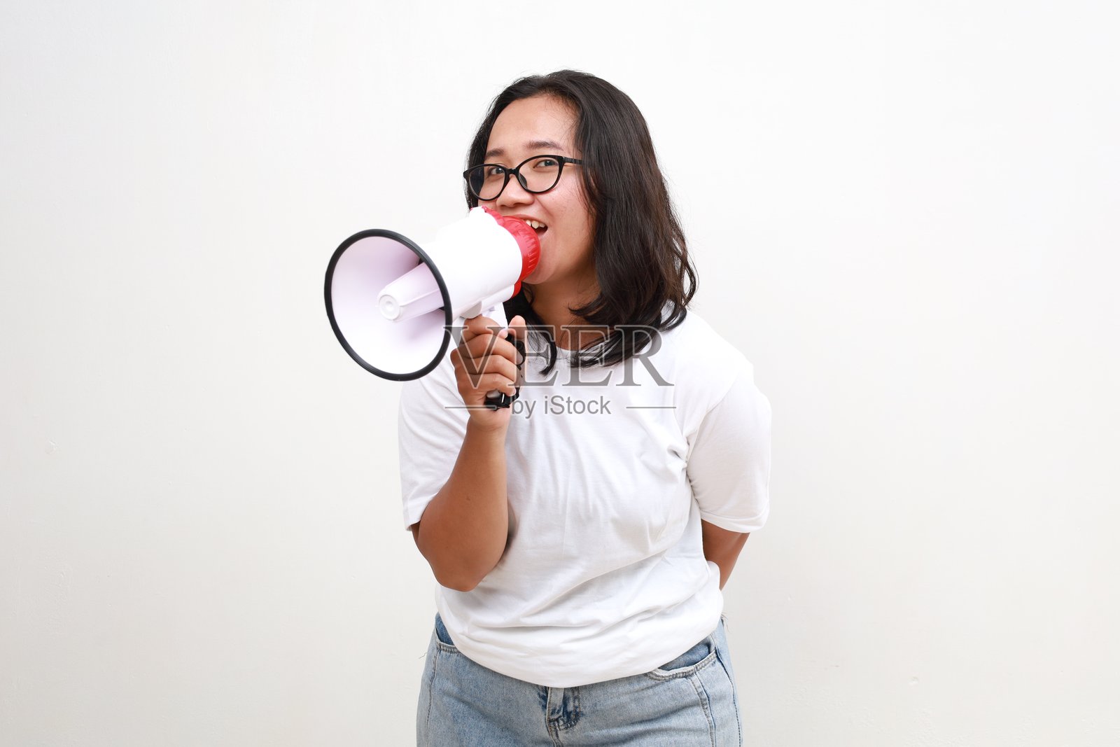 快乐微笑的年轻亚洲女子拿着扩音器孤立在白色背景，演讲和宣布概念照片摄影图片