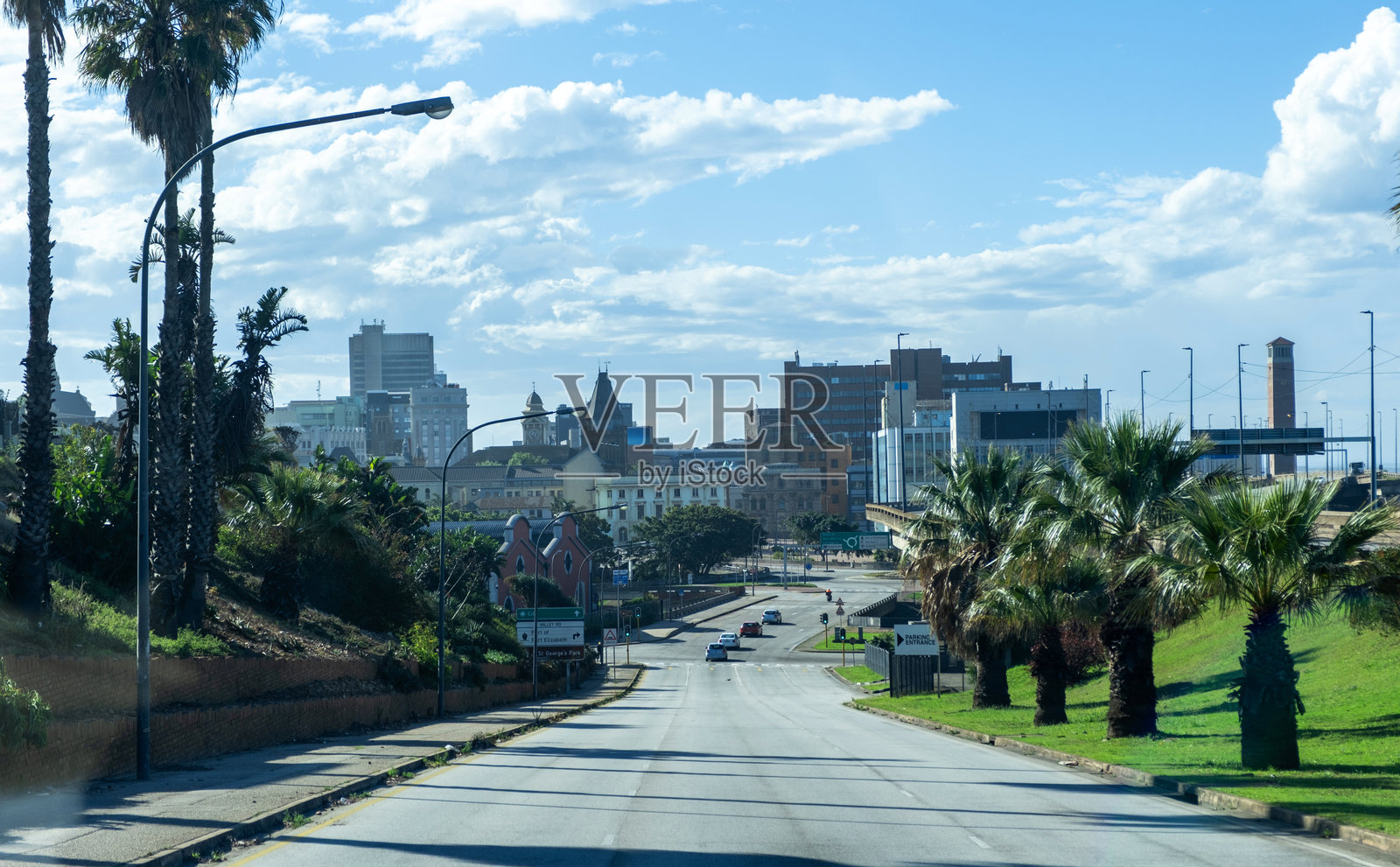 南非港艾丽莎白。驶向城市，高楼大厦，棕榈树和多云的蓝天。照片摄影图片