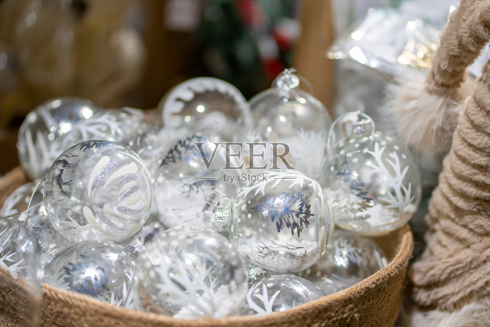 许多透明玻璃圣诞球放在米色纺织篮子里照片摄影图片