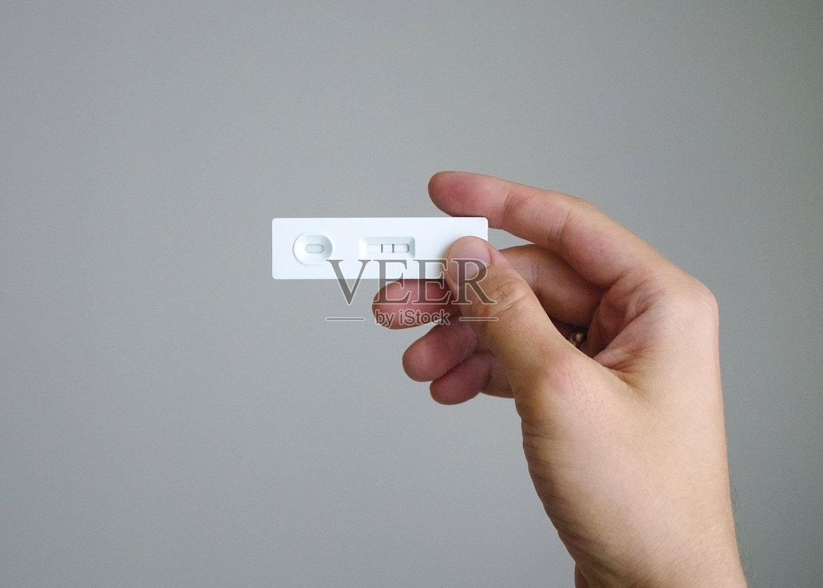 手中抗原新冠病毒检测呈阳性，意味着该人感染了病毒，需要治疗。照片摄影图片