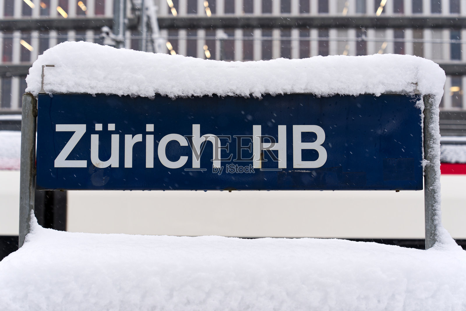 瑞士苏黎世市火车总站的蓝白色雪覆盖金属标志特写，拍摄于一个雪花纷飞的秋日。照片摄影图片