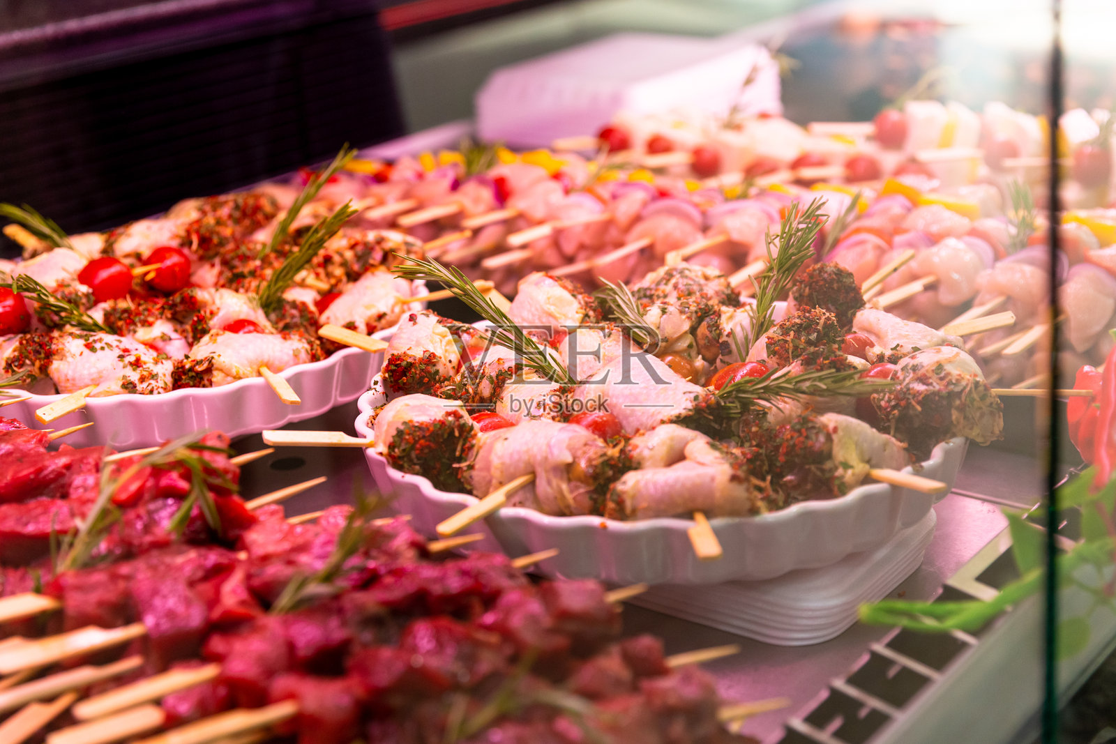 用混合胡椒和迷迭香调味的生鸡肉卷串。照片摄影图片