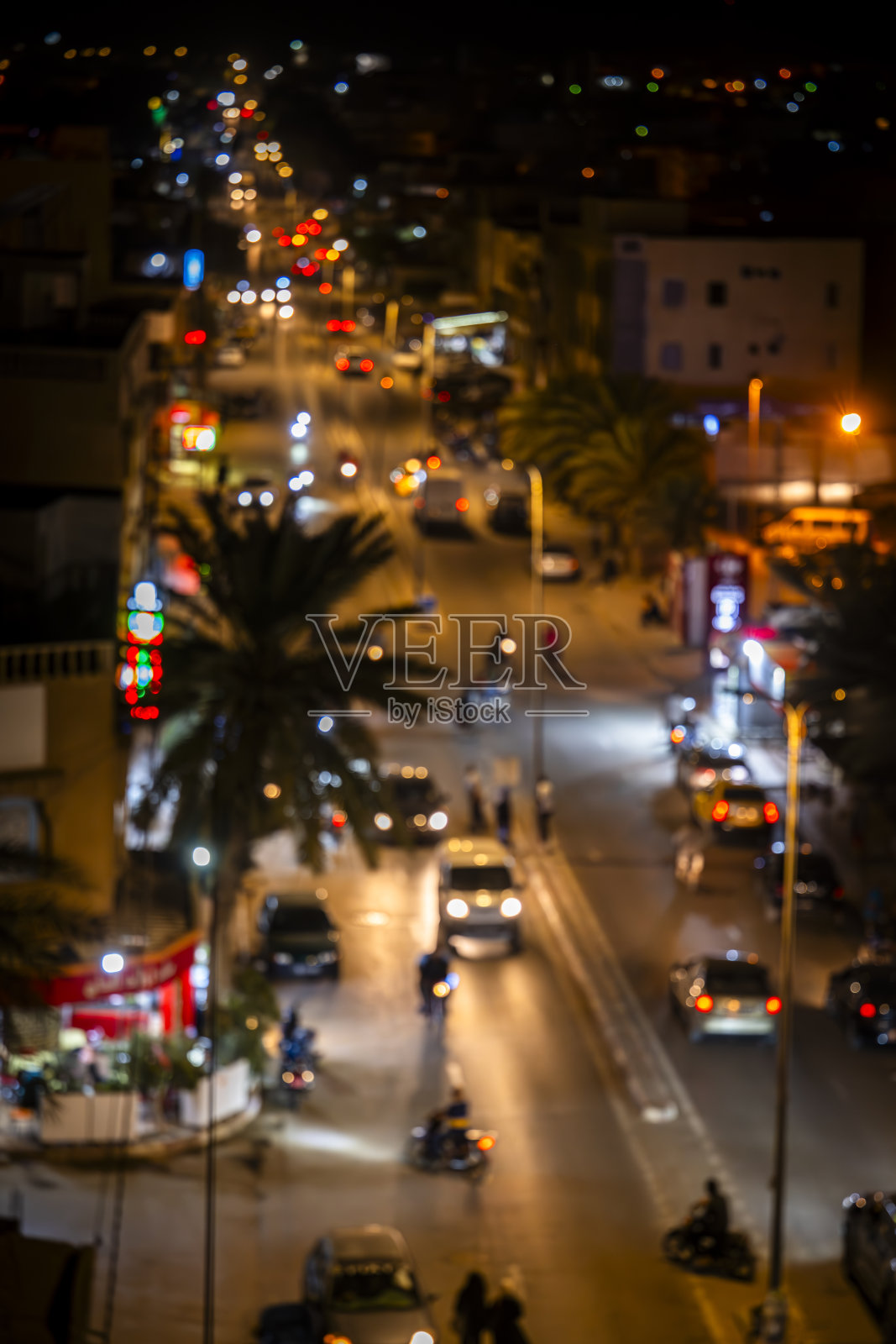 傍晚时分中央城市街道的照片，模糊的车灯和霓虹灯招牌。照片摄影图片