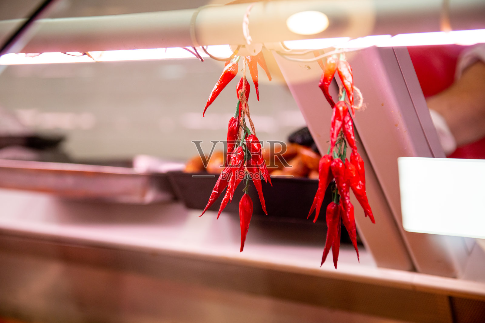 肉店窗户上挂着辣椒。照片摄影图片
