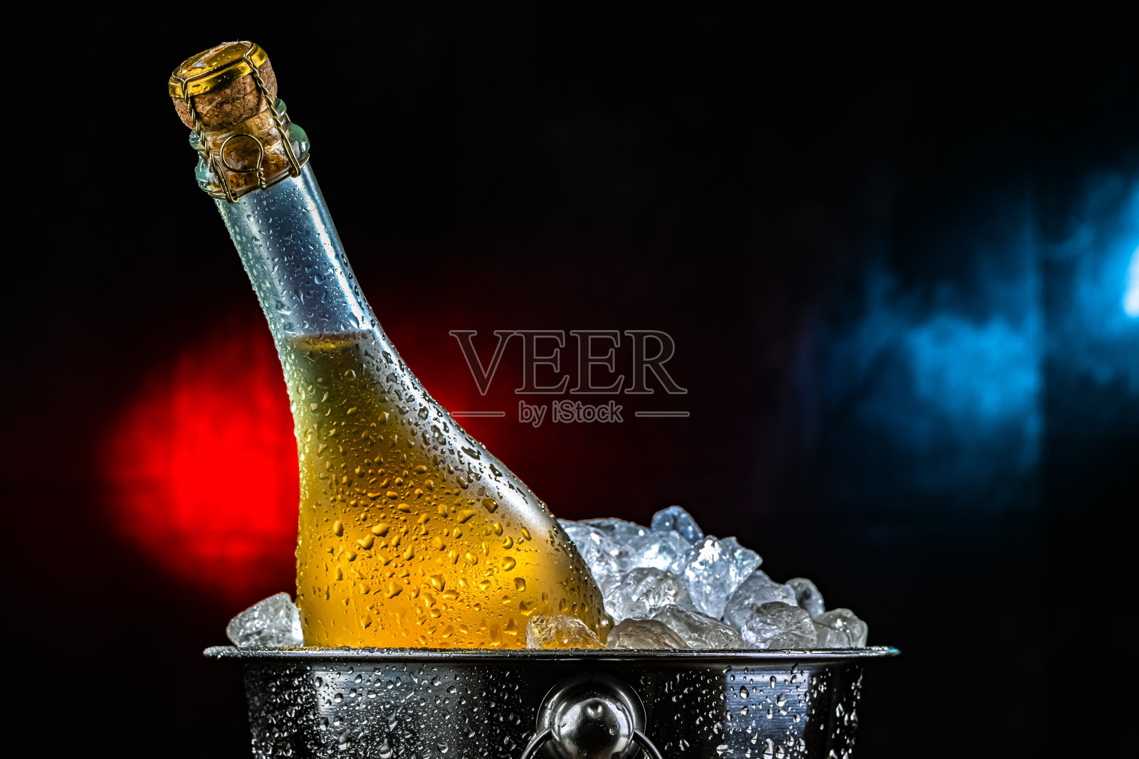 装有碎冰的冰桶中的起泡酒瓶。照片摄影图片
