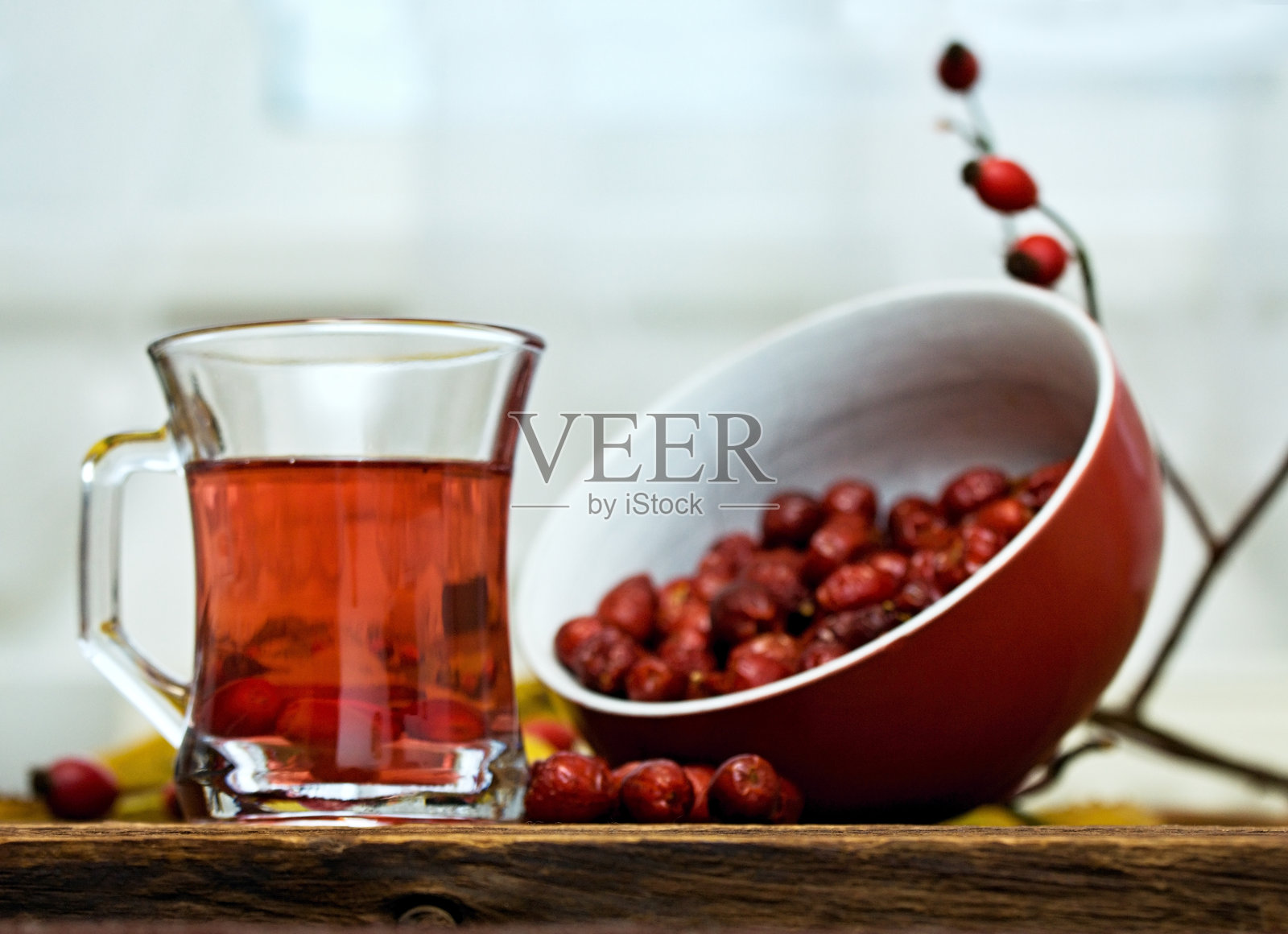 富含维生素的玫瑰果茶和一碗干玫瑰果。照片摄影图片