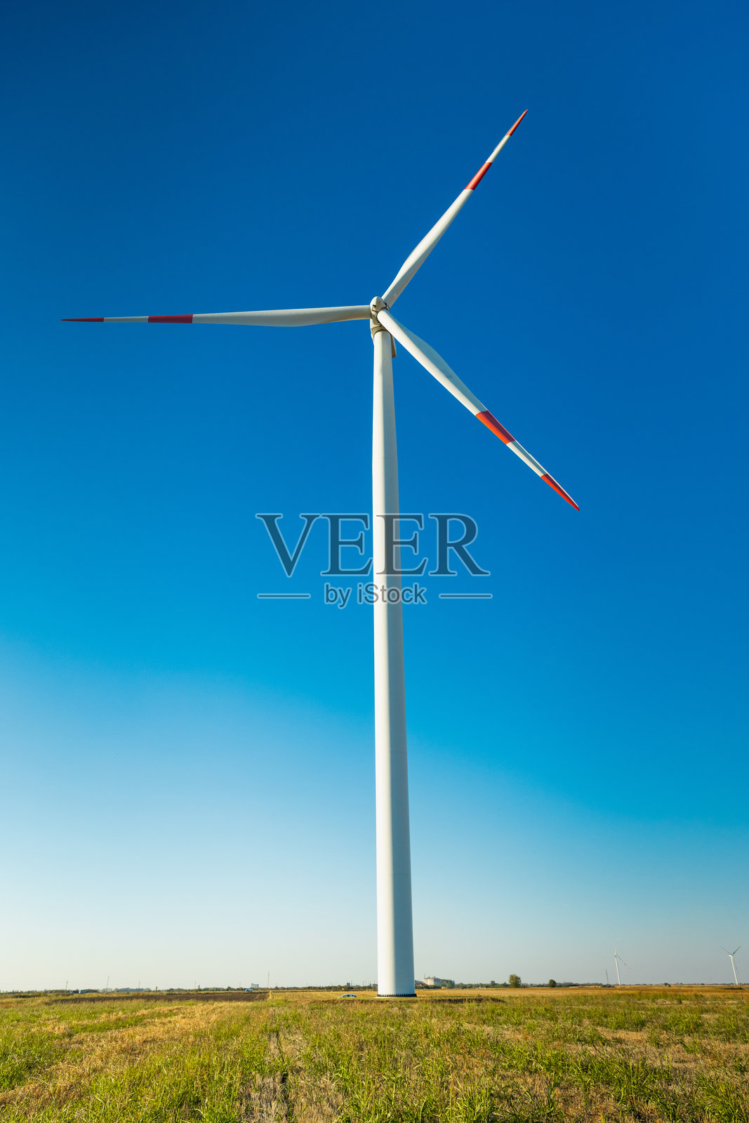 开阔地带的广角镜头拍摄的风力涡轮机 - 明亮阳光下的可再生能源风电场与风力涡轮机照片摄影图片