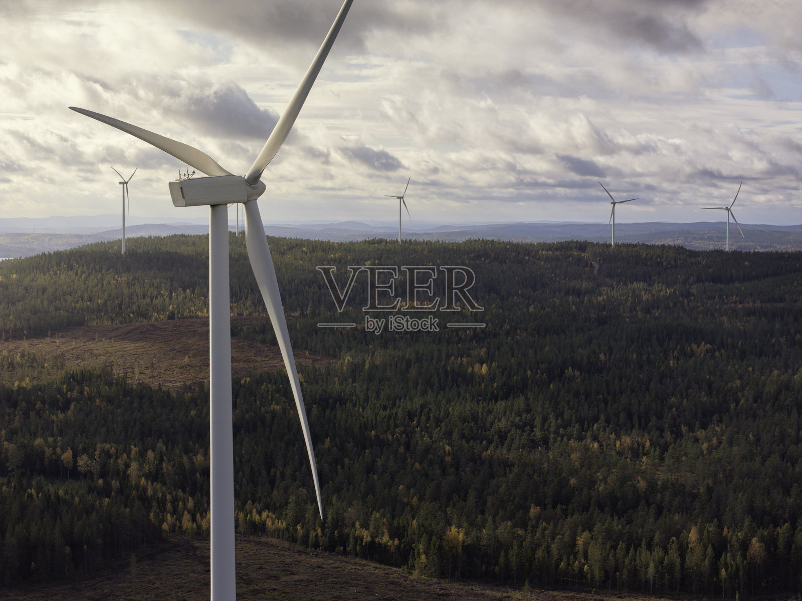森林景观中的山丘与风力发电机照片摄影图片