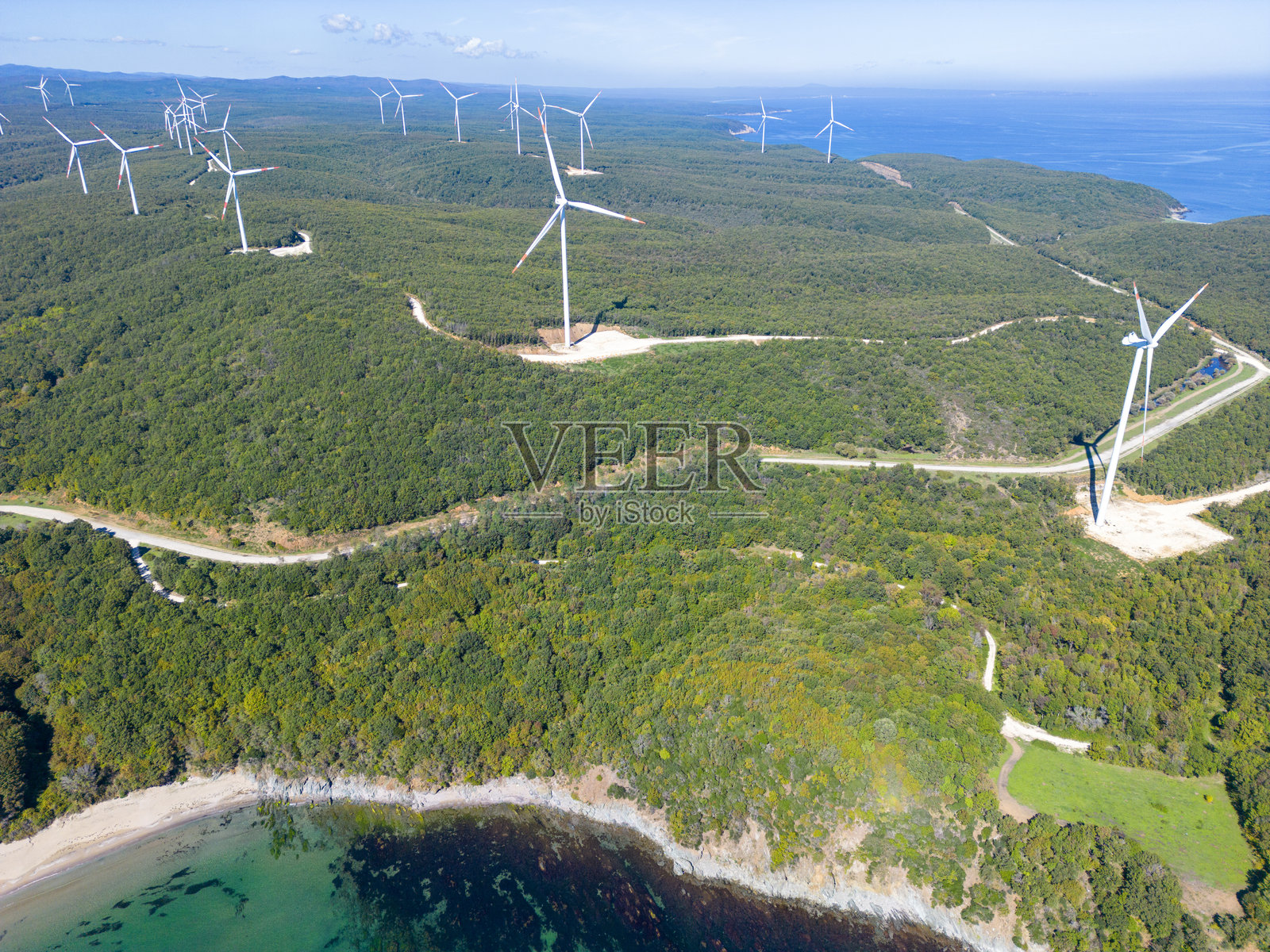 海边森林中的风力涡轮机鸟瞰图照片摄影图片