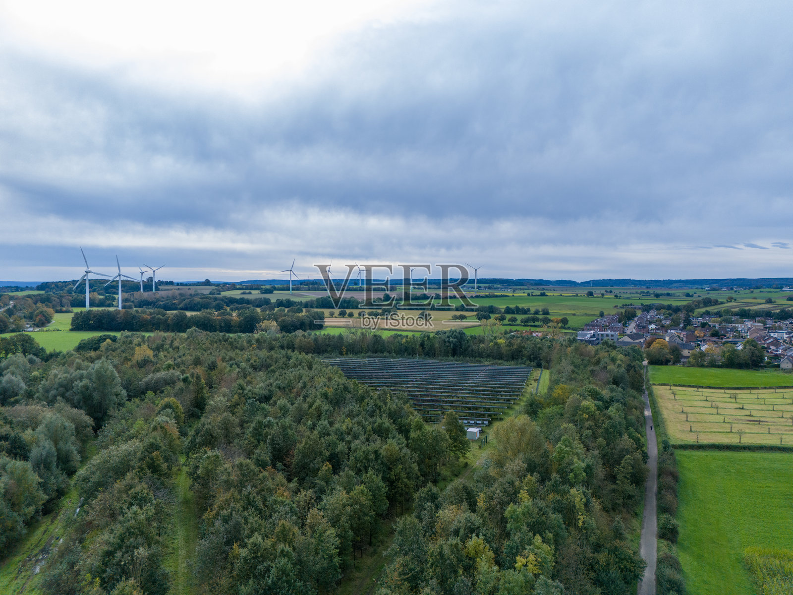 空中无人机视角，远处的太阳能电池板和风力涡轮机照片摄影图片