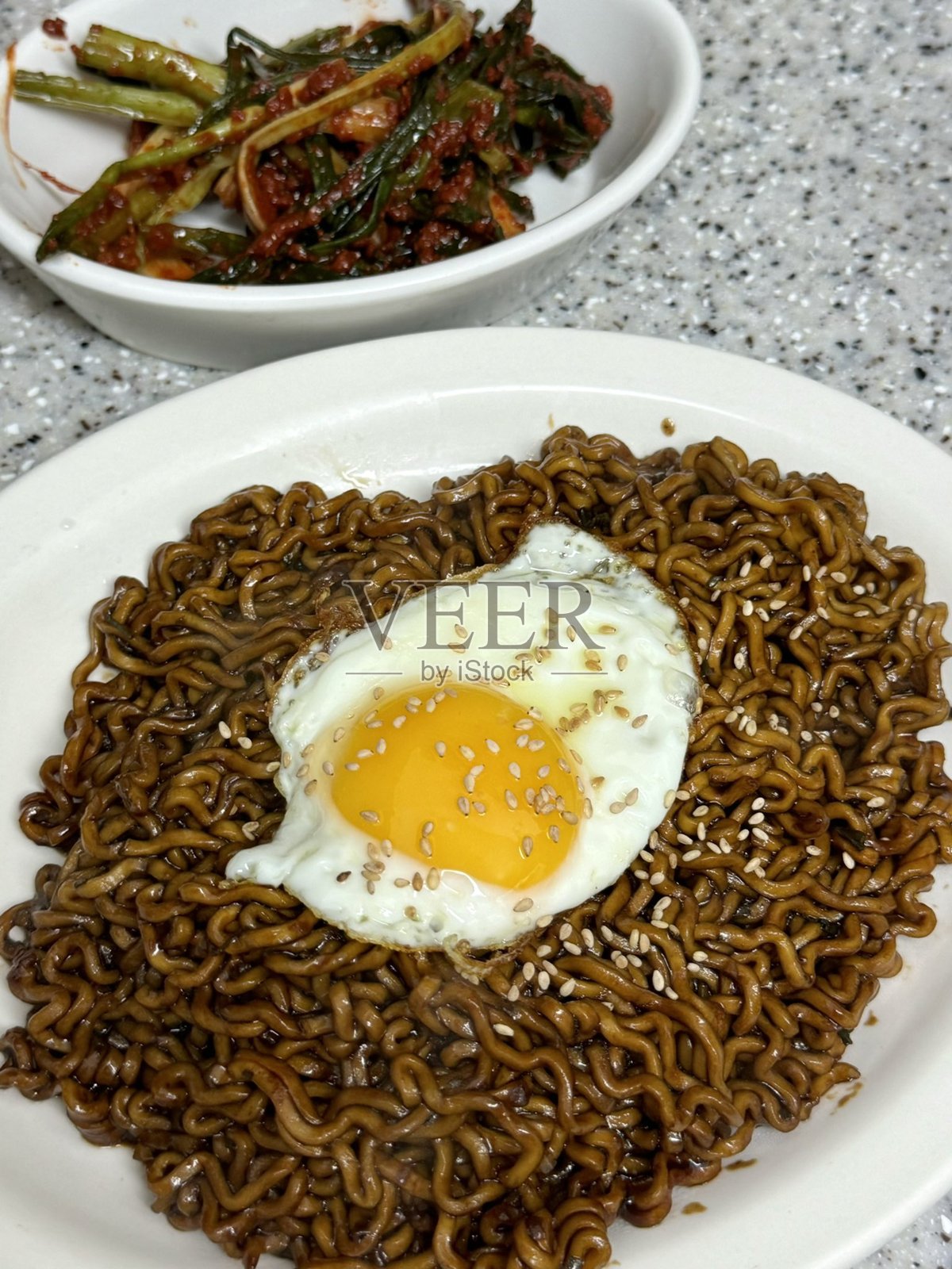 美味的炸酱面，配有浓郁的黑豆酱，撒上青葱和芝麻。这是一道令人舒适的韩国经典，每一口都充满了深度和风味。照片摄影图片