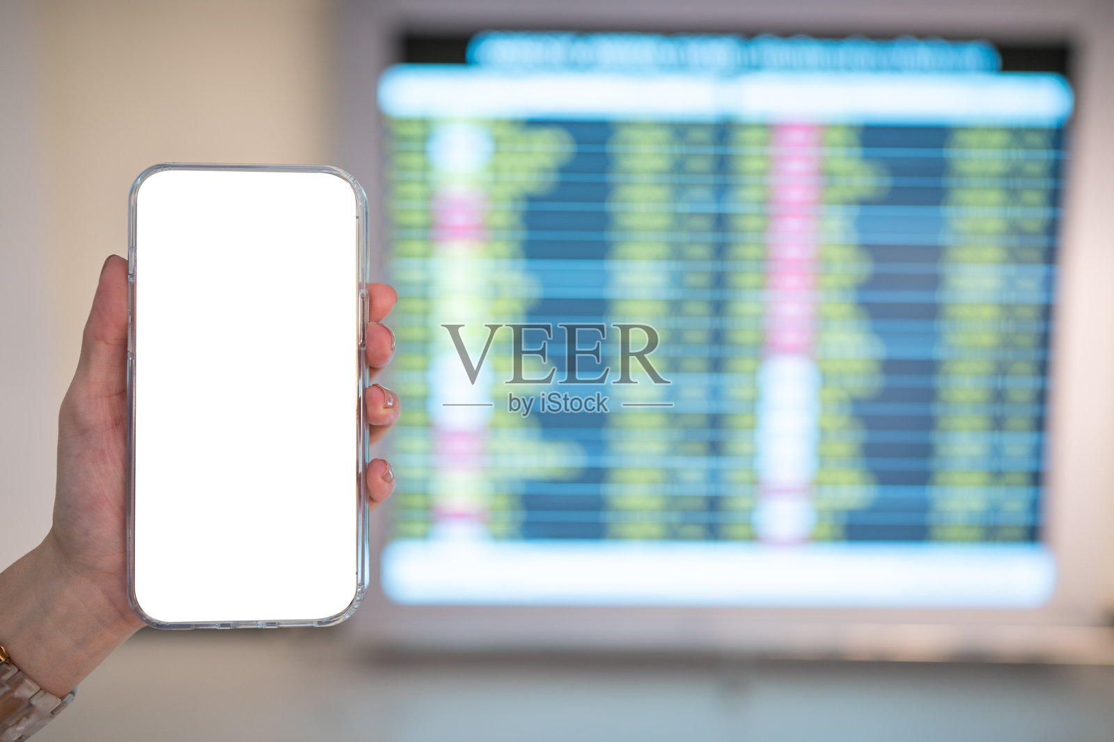 手持智能手机，机场背景下的空白屏幕时间表。照片摄影图片