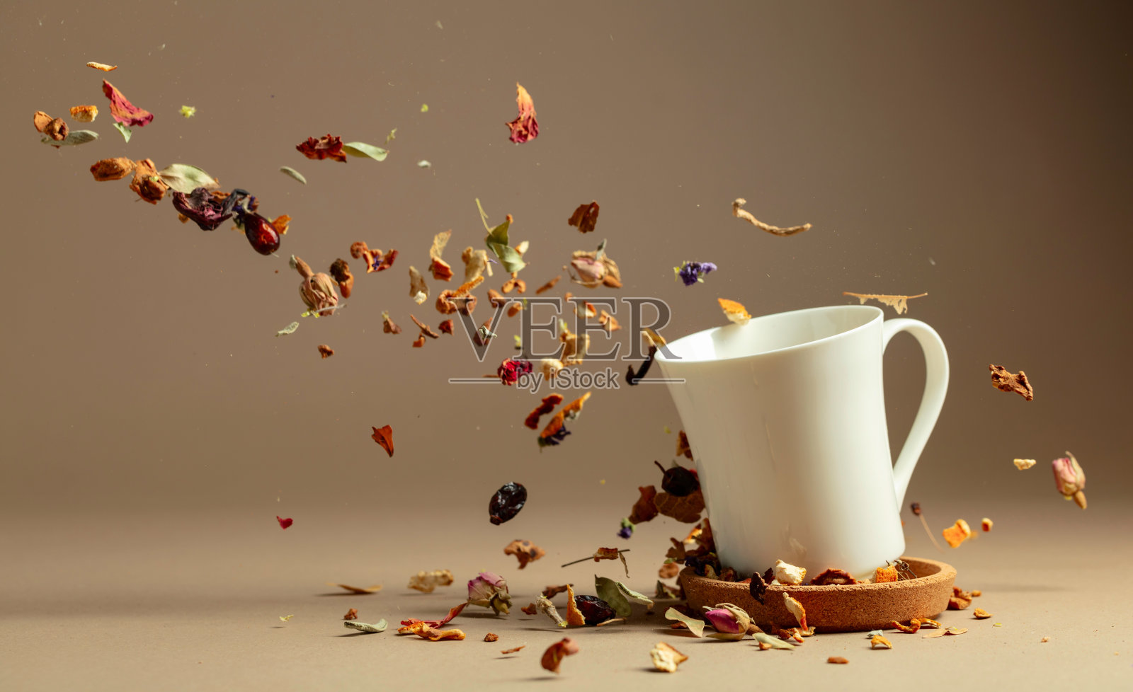 草药茶的原料被倒入一个白色的杯子里。照片摄影图片