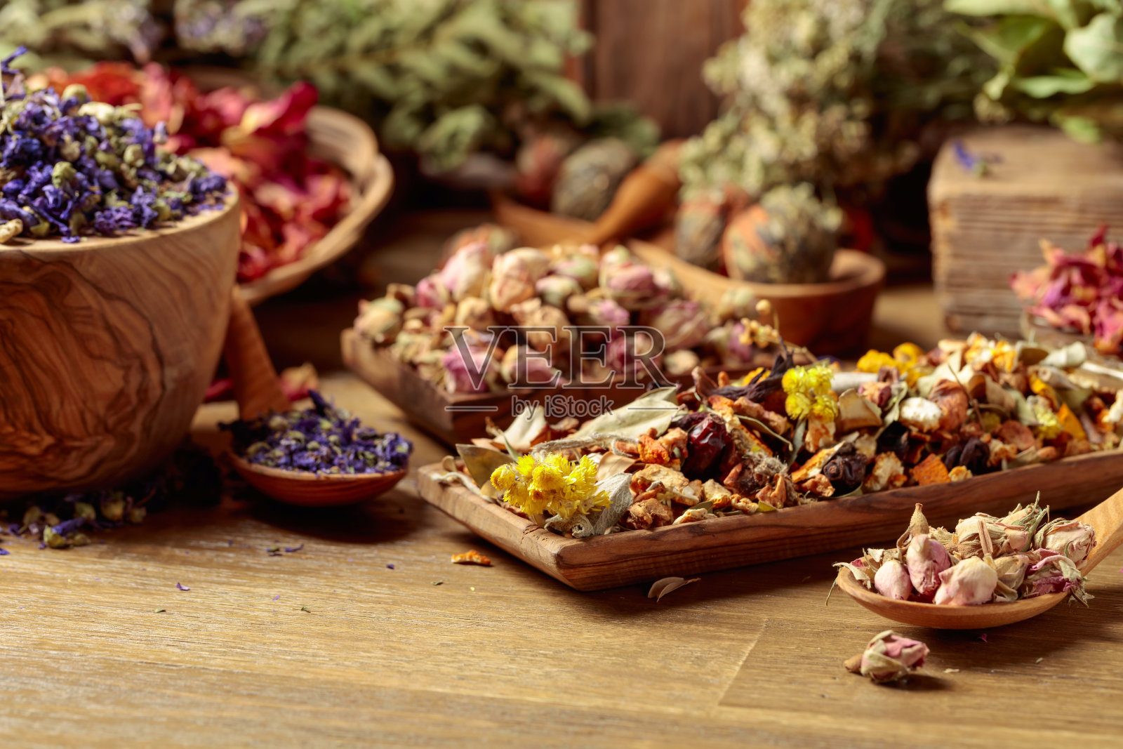 各种干燥的药用植物、草药和花卉在古老的木质背景上。照片摄影图片