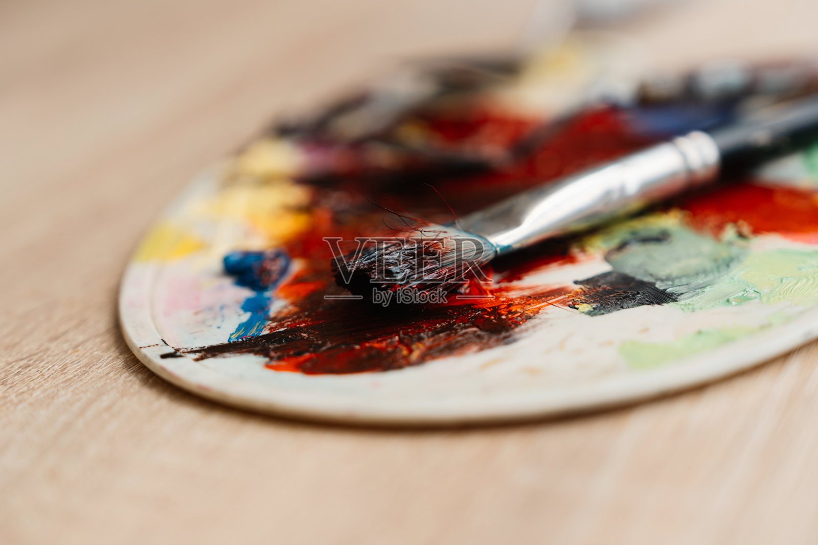 五彩斑斓的调色板和放在木质表面的画笔照片摄影图片