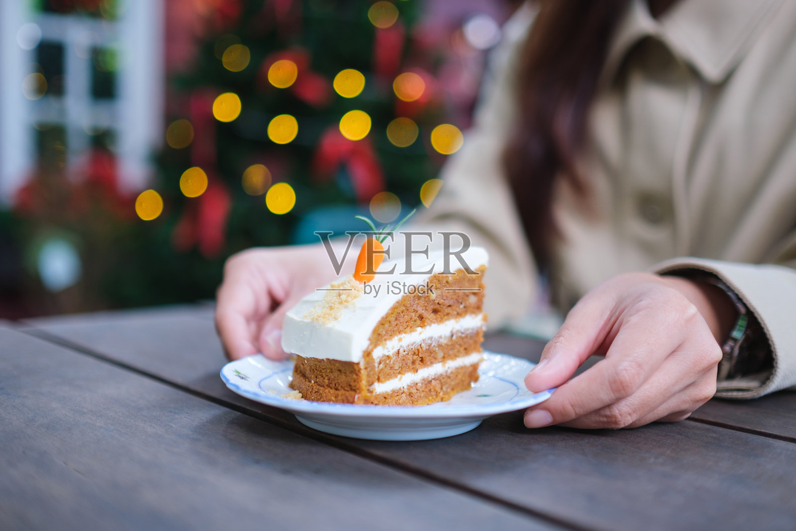 女人在圣诞派对上端着一盘胡萝卜蛋糕的特写镜头照片摄影图片