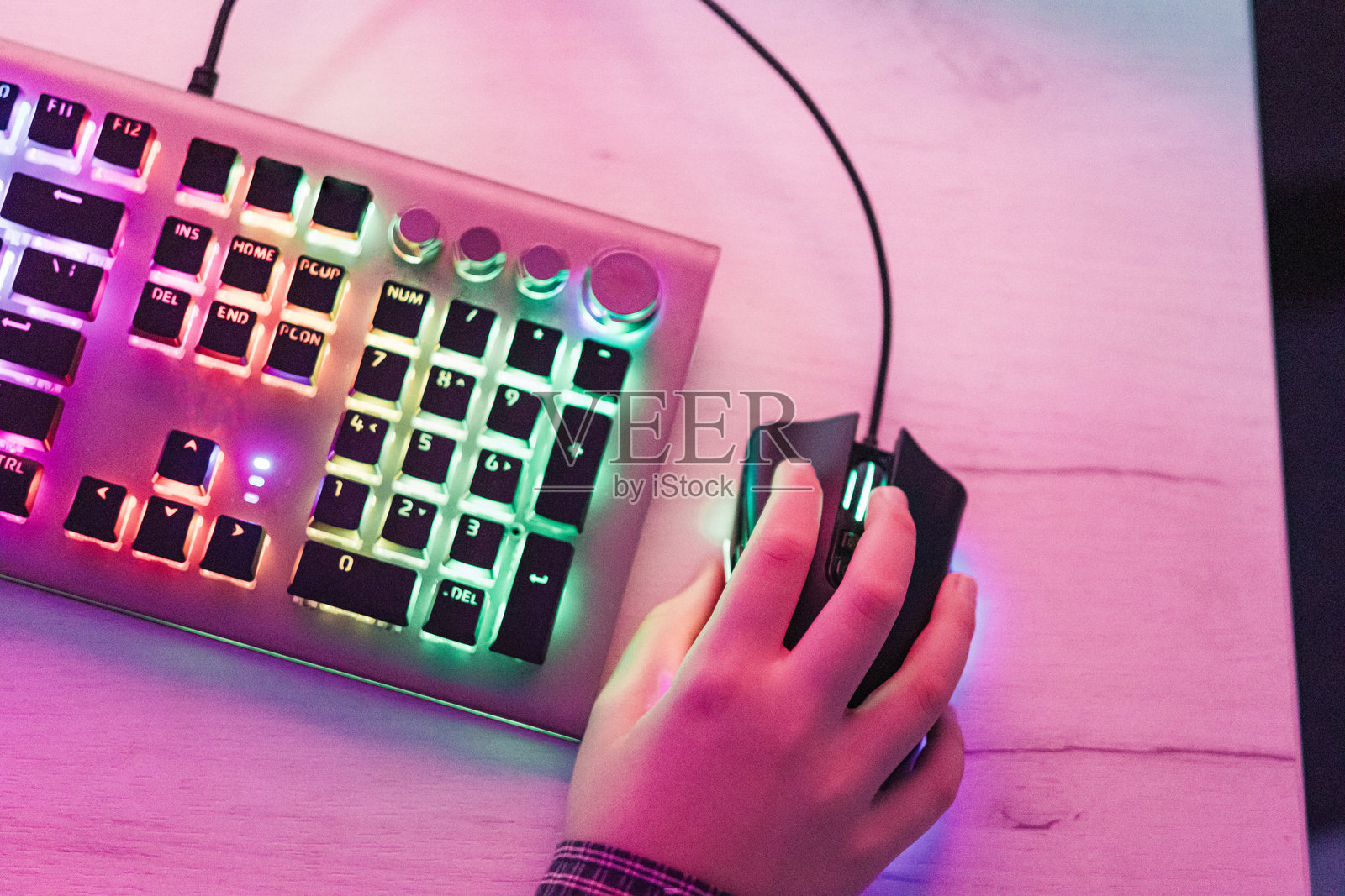 男孩玩电脑游戏时的手部特写，配有RGB电脑键盘和鼠标。儿童游戏成瘾。照片摄影图片