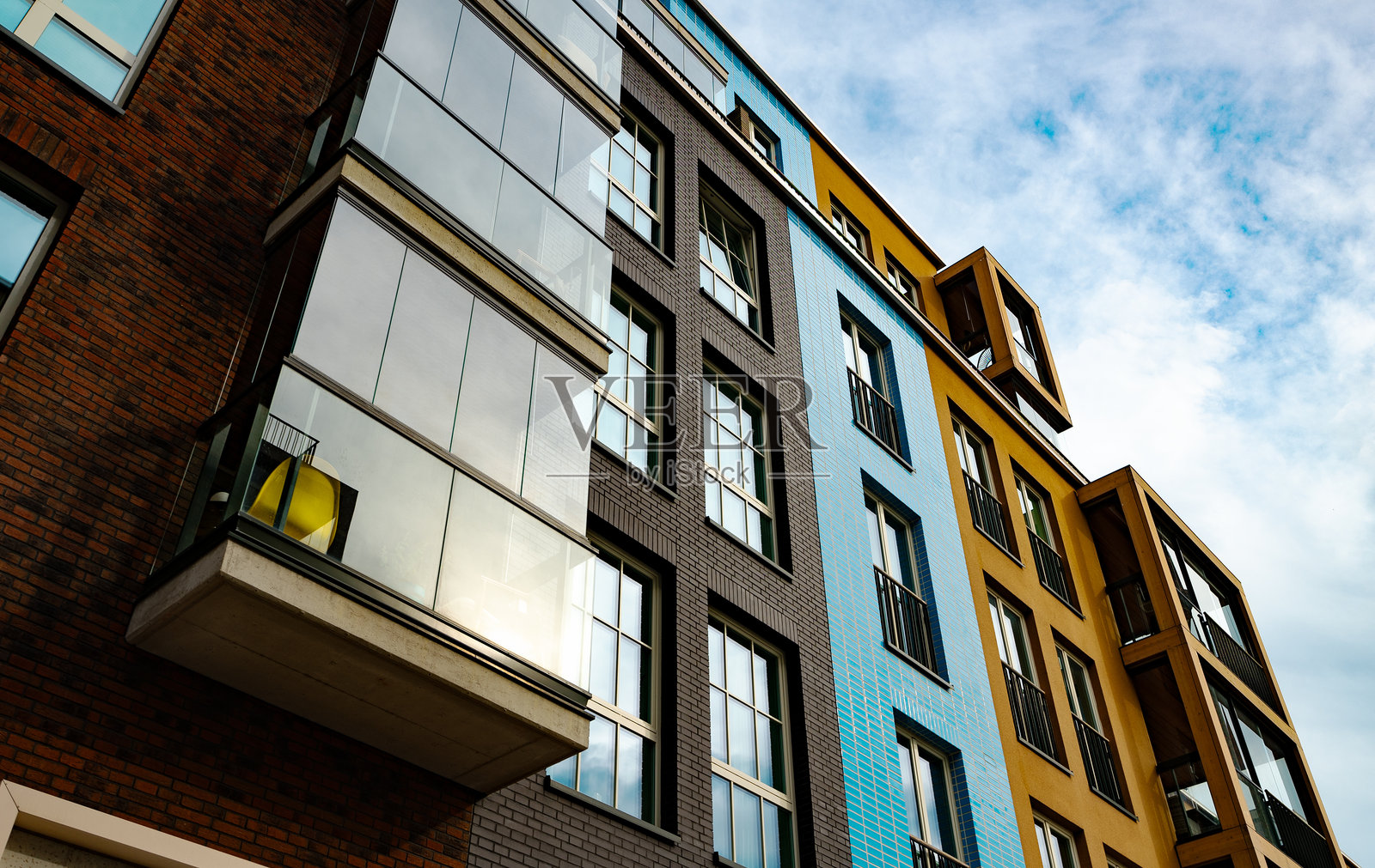 现代公寓楼，配有玻璃阳台和工业元素。照片摄影图片