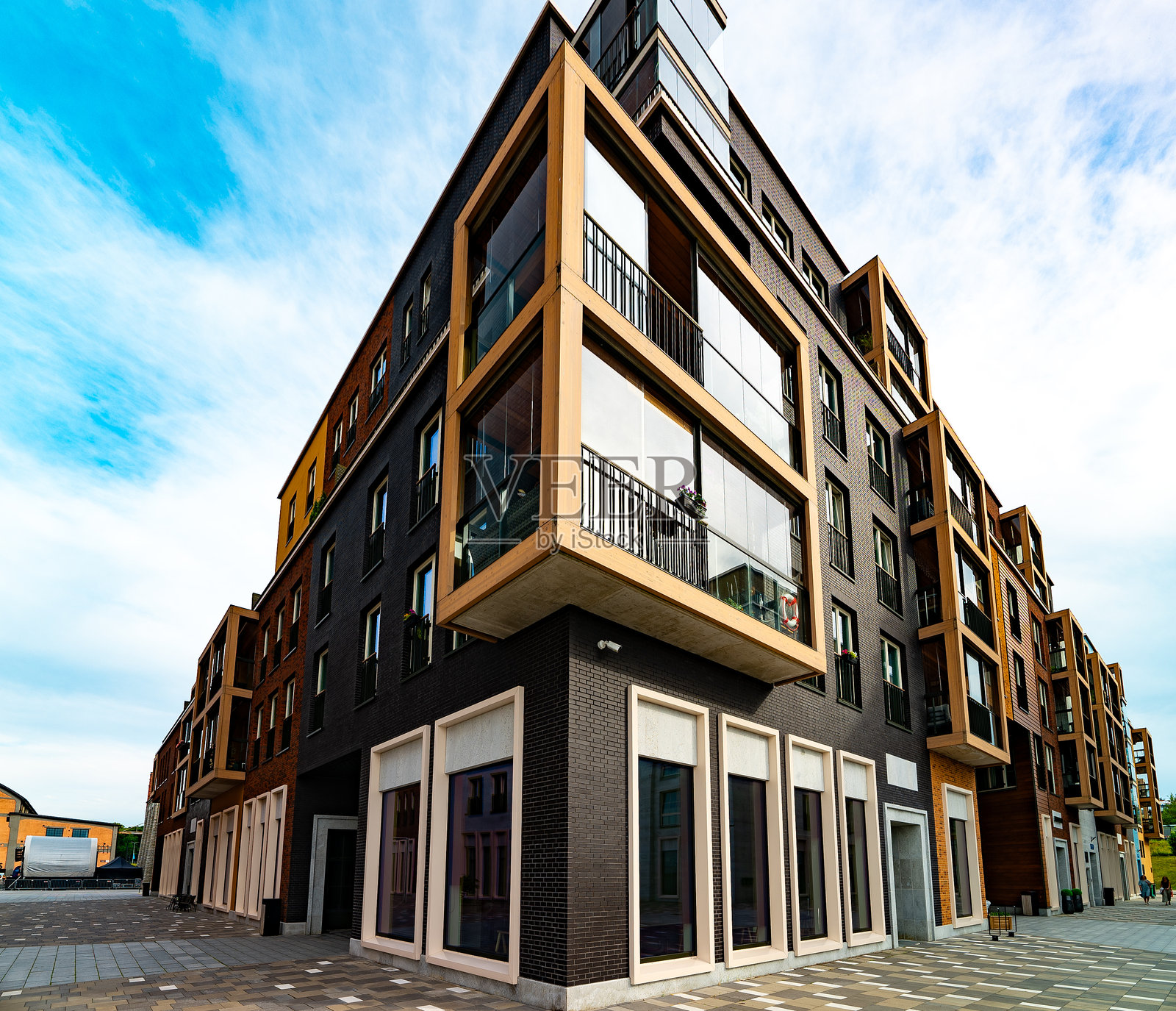 现代公寓楼，配有玻璃阳台和工业元素。照片摄影图片