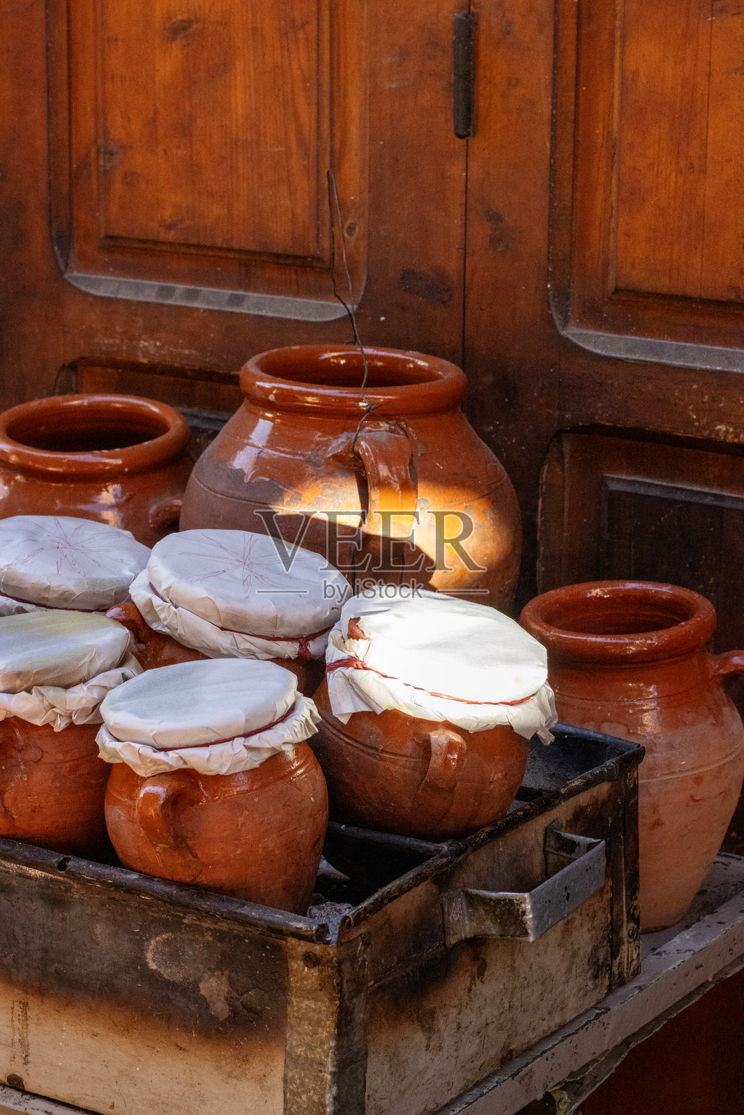 摩洛哥马拉喀什清晨特写的陶土塔吉锅，盖着布料，放在火上。照片摄影图片