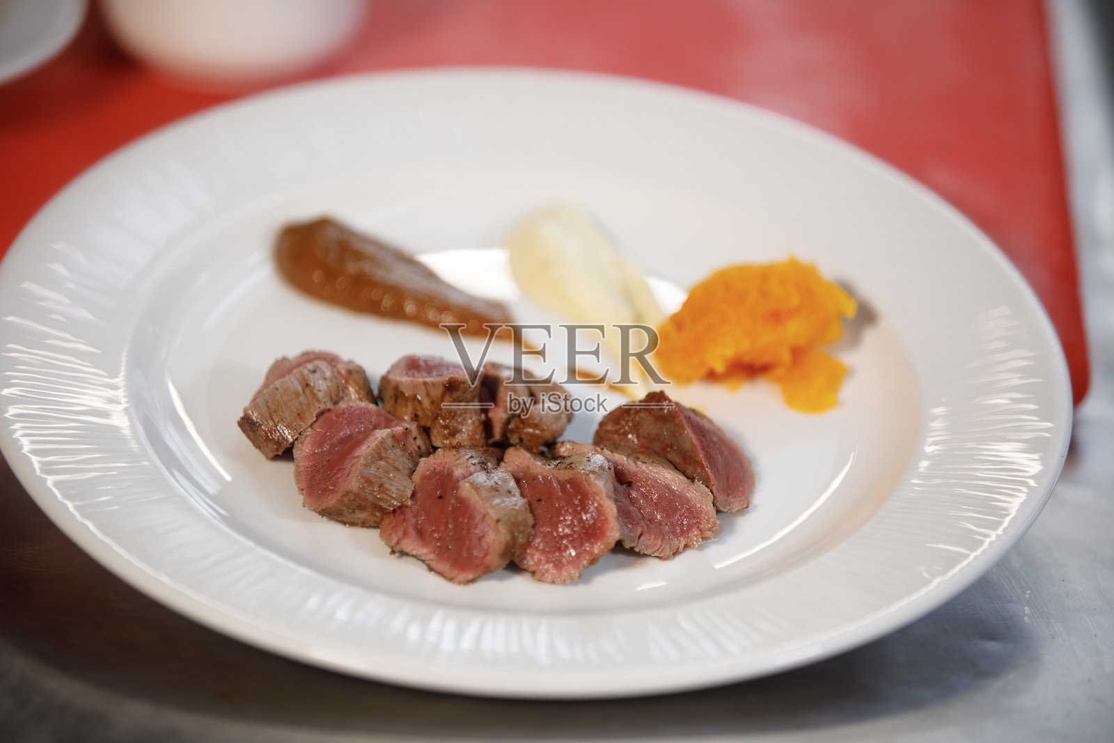 准备好食用的盘子，里面有熟肉和旁边的调味汁照片摄影图片