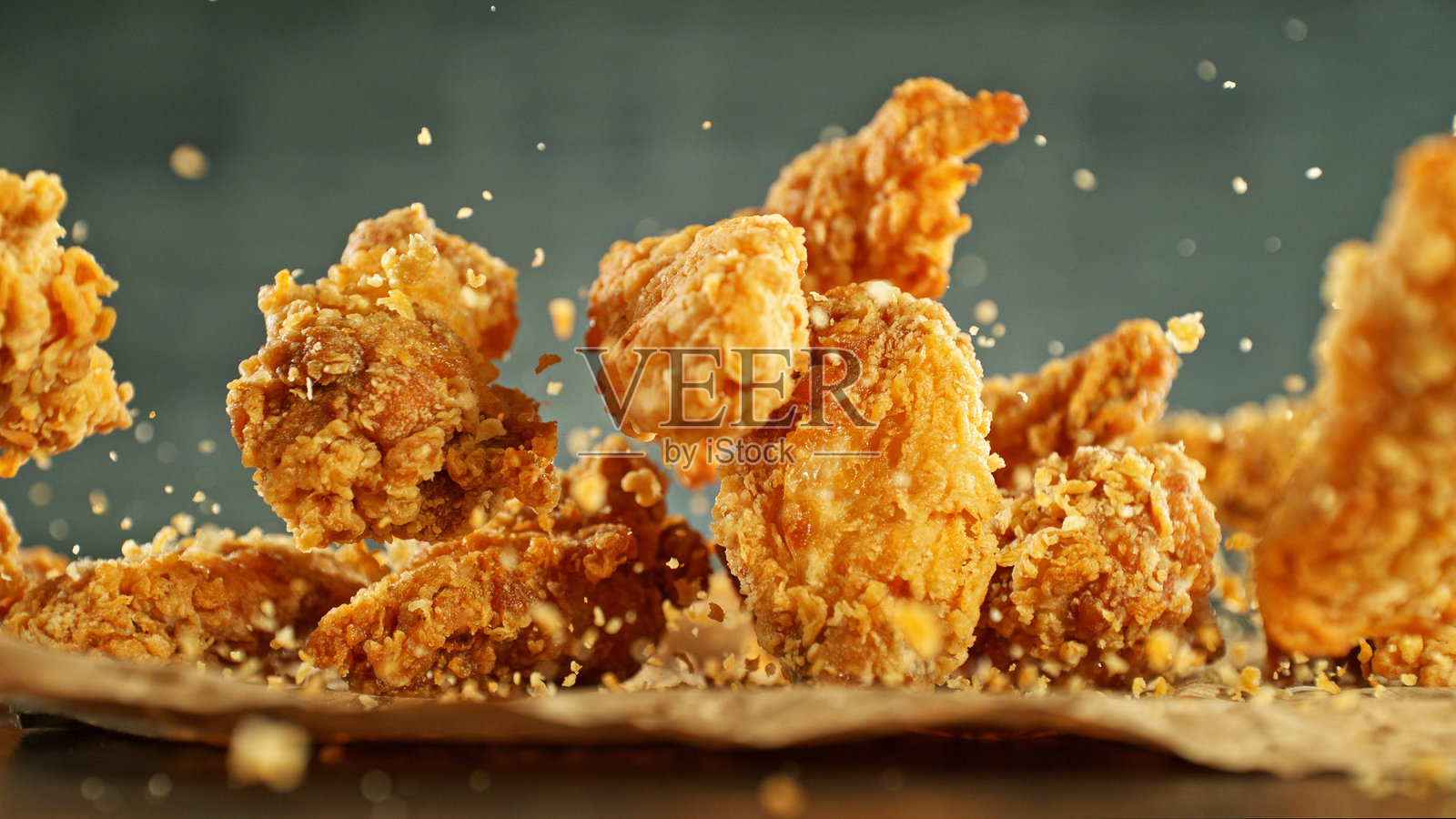 飞舞的炸鸡块的动态冻结。照片摄影图片