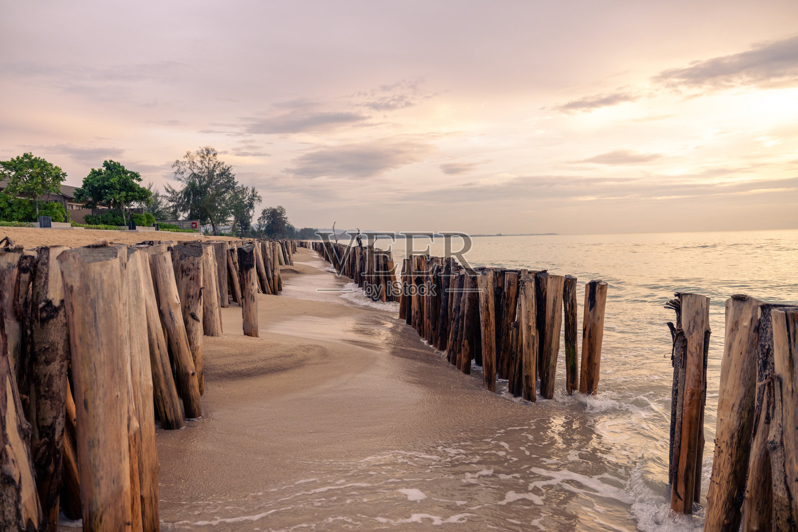 宁静的海滩在日落时分与木质防波堤照片摄影图片