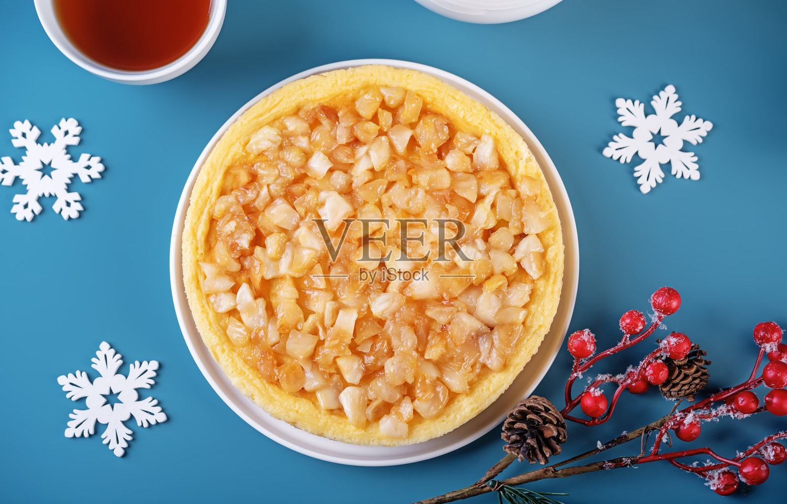 蓝色背景上的圣诞焦糖苹果奶酪蛋糕照片摄影图片