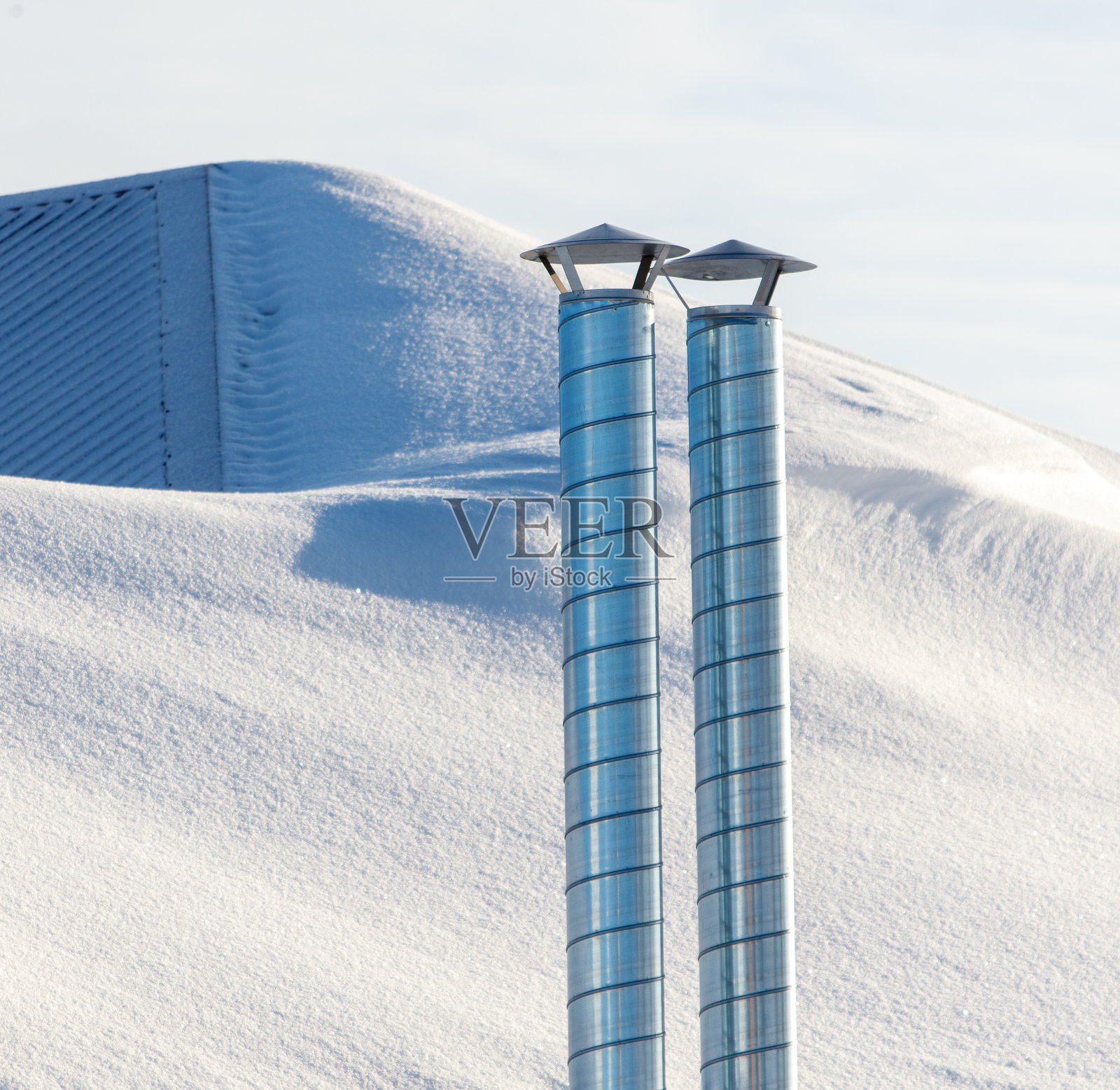 两根金属管道在雪山上照片摄影图片