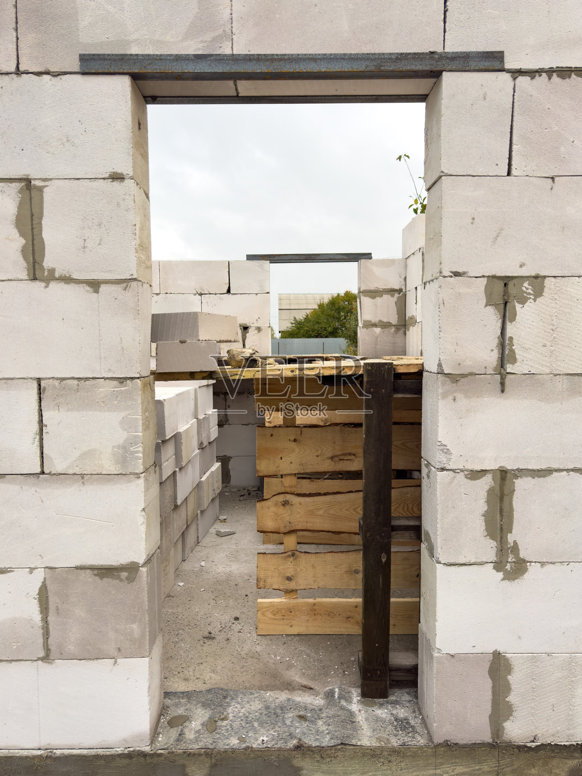 一扇砖砌的门敞开着，露出一个木地板的房间照片摄影图片