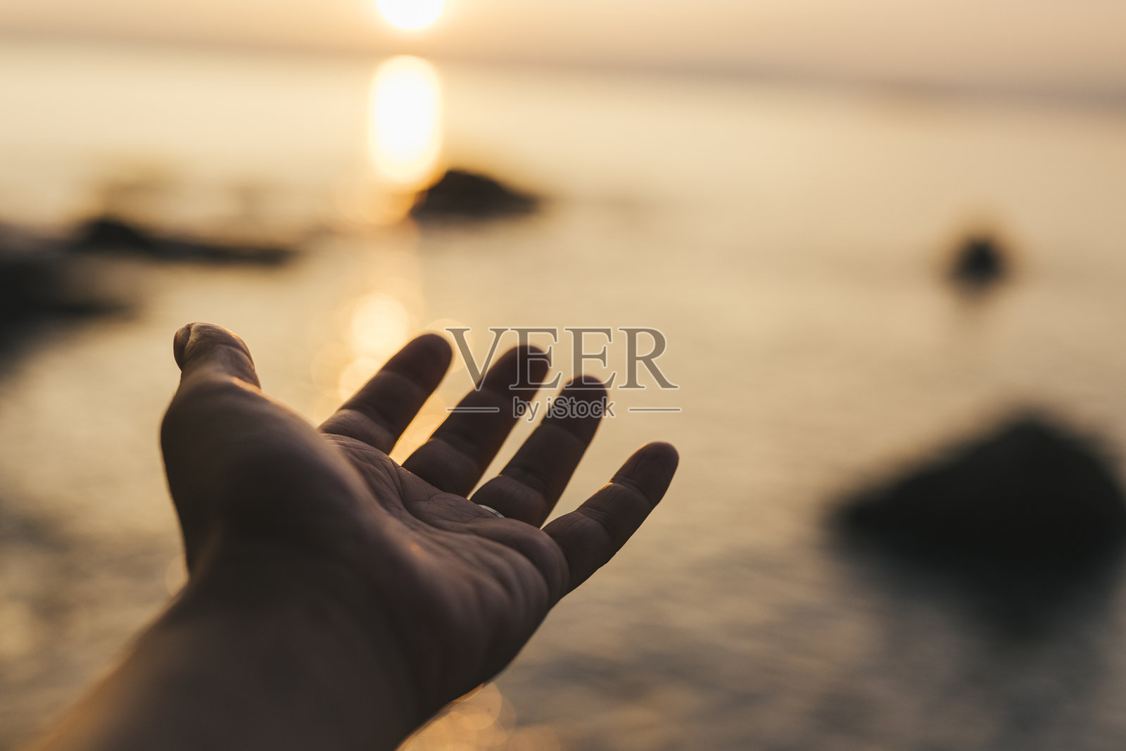 男人在海滩上的手照片摄影图片