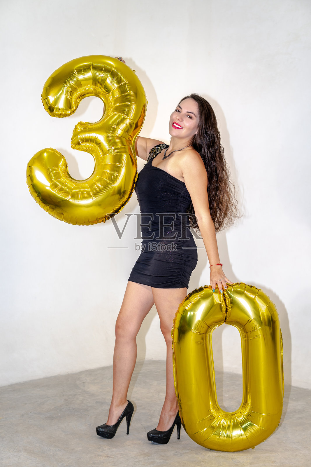 女性庆祝30岁生日，手持金色气球照片摄影图片