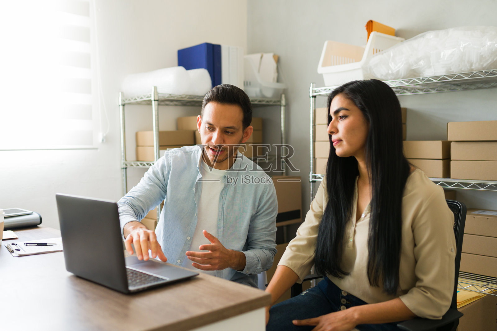 拉丁裔企业家在他们的储藏室里勤奋地管理着他们的小生意。照片摄影图片