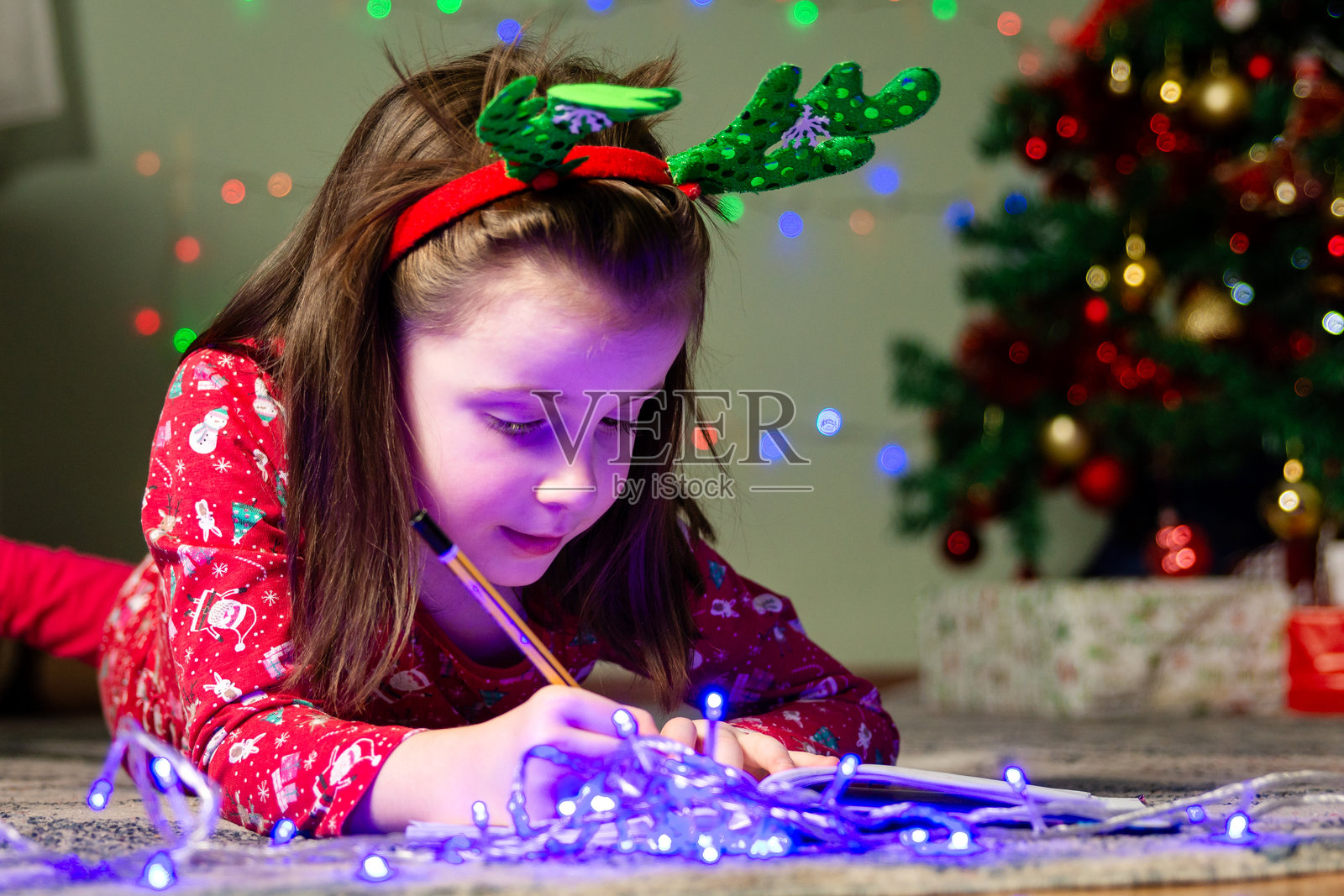 可爱的女孩在家里给圣诞老人画画照片摄影图片