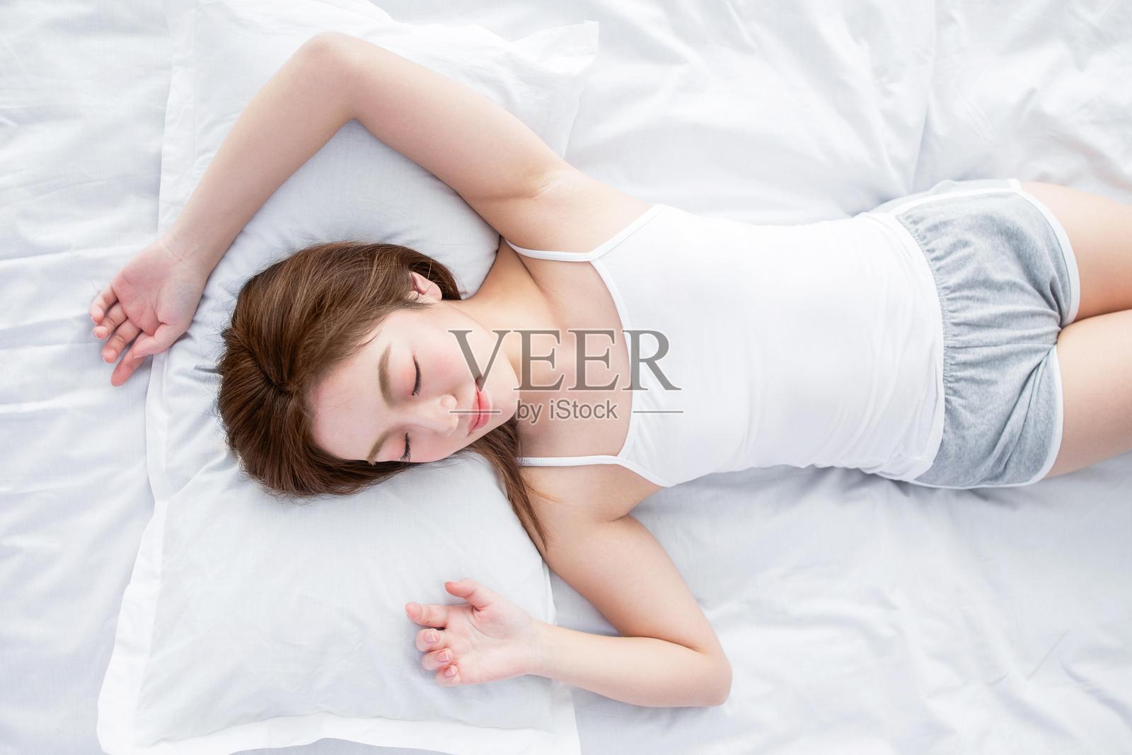 一位女性在床上睡觉照片摄影图片