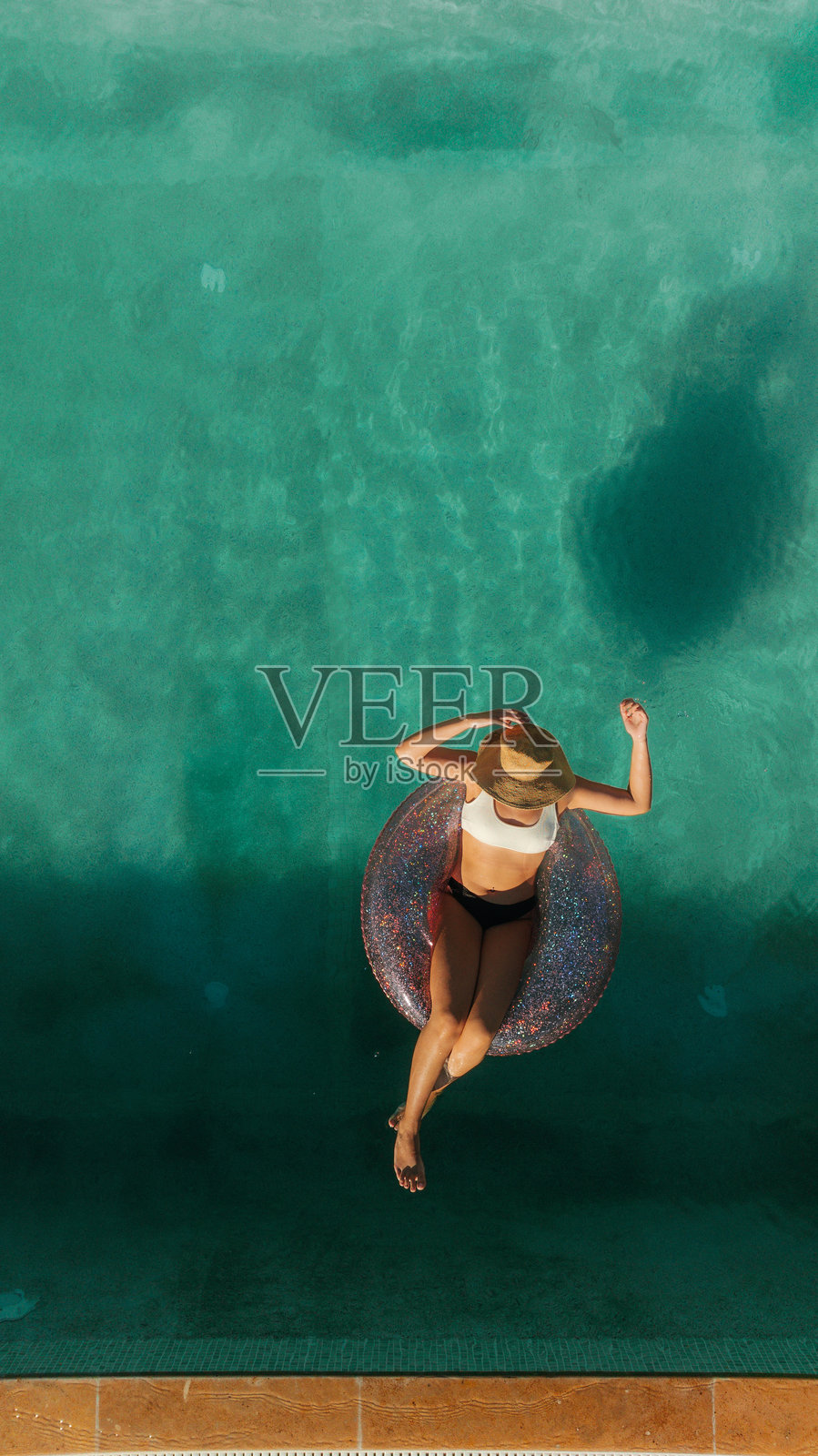 女人在泳池中放松。照片摄影图片