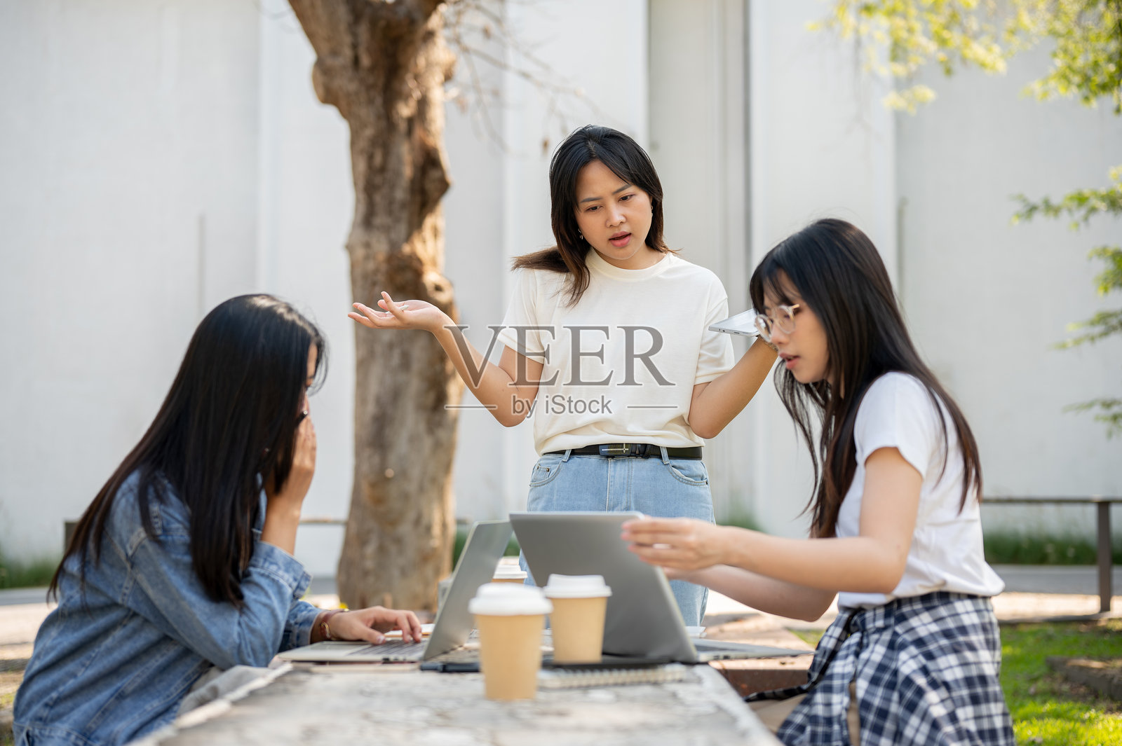 一名学生正在与朋友进行严肃的对话，表达对项目问题的担忧。照片摄影图片