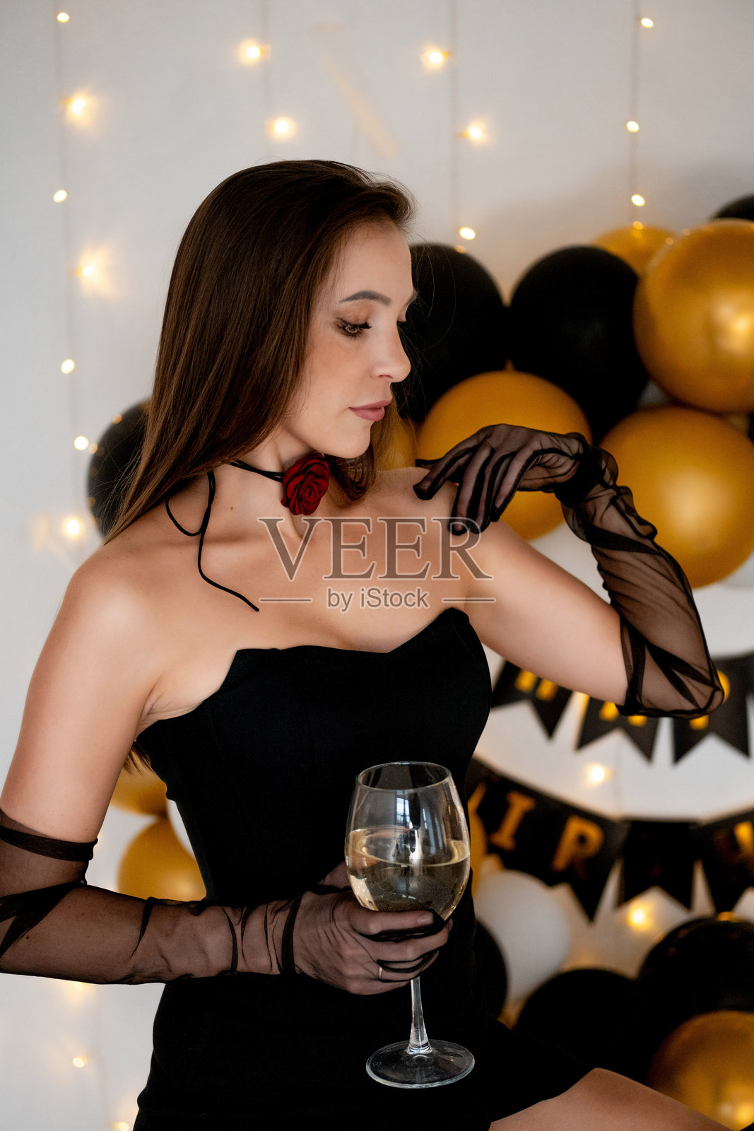 一个女孩庆祝她的生日，一个年轻女孩在节日的拍照区与气球一起欢庆这个节日。照片摄影图片