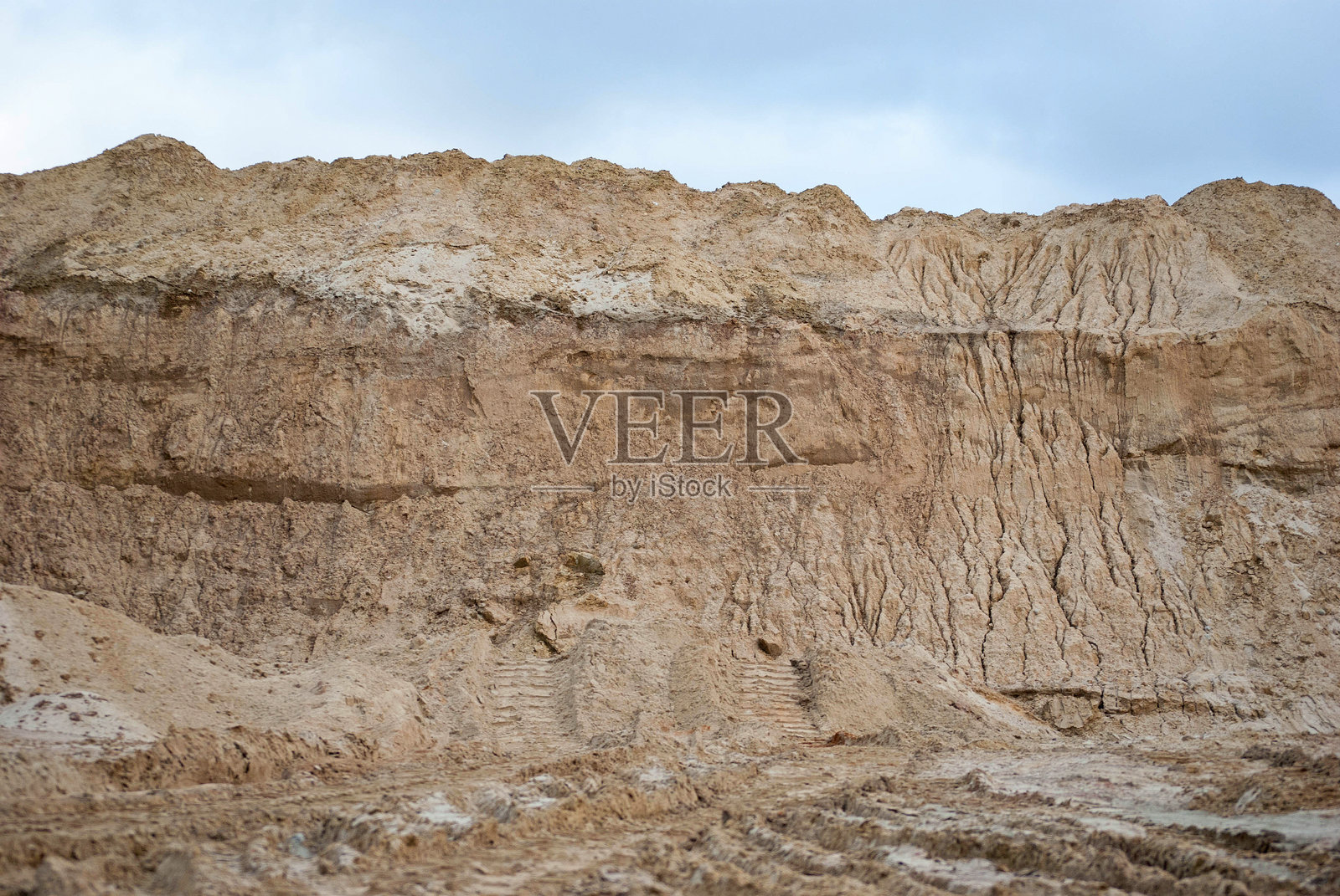 沙石采石场的墙壁。从下方俯视挖掘的斜坡照片摄影图片