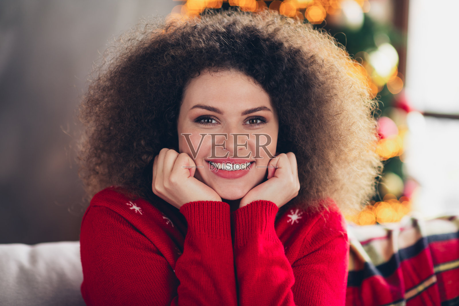 穿着新年印花毛衣的迷人可爱女性在公寓室内享受魔幻的圣诞节周末时光照片摄影图片