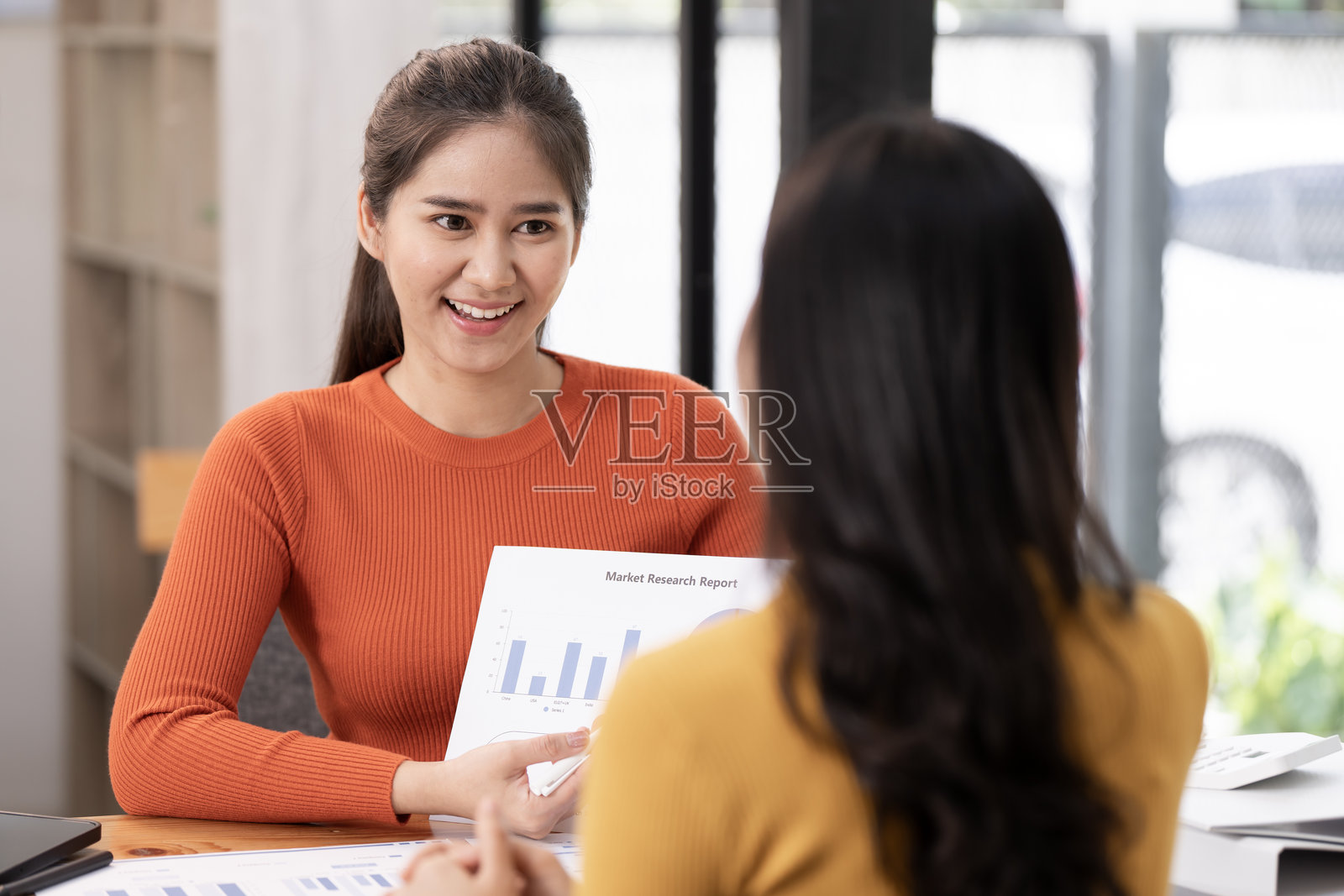 两位年轻的亚洲女商人在办公室讨论和咨询新的创业项目创意展示。照片摄影图片