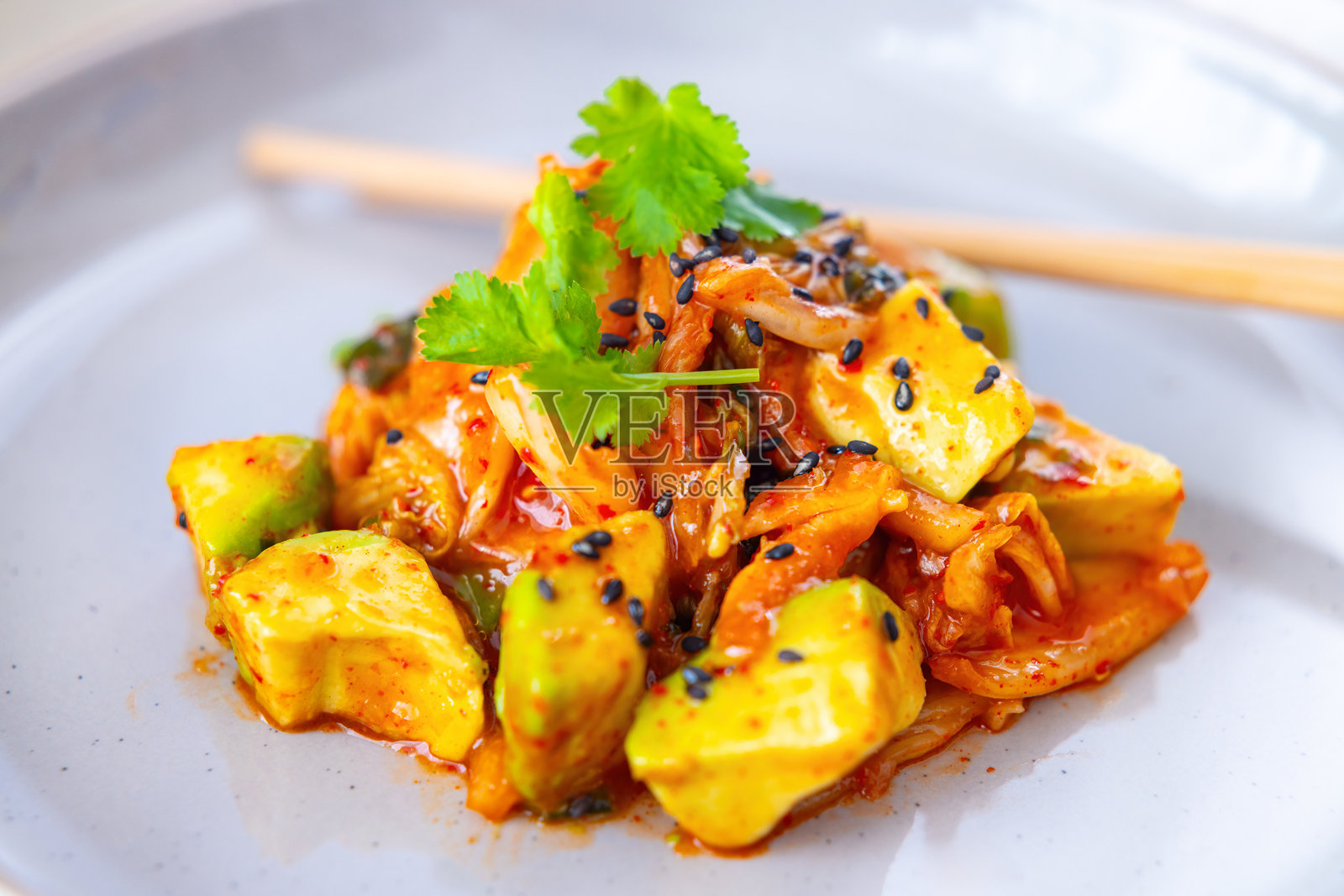 黑芝麻装饰的鳄梨和泡菜沙拉，放在陶瓷盘上的特写镜头照片摄影图片