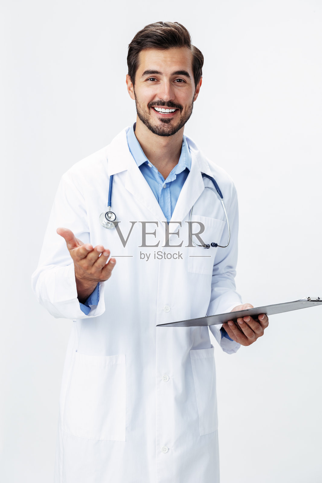 穿着白大褂的男医生，手持听诊器和病历夹，微笑着看向镜头，背景为白色，留有空白空间，适合添加文字，健康主题。照片摄影图片