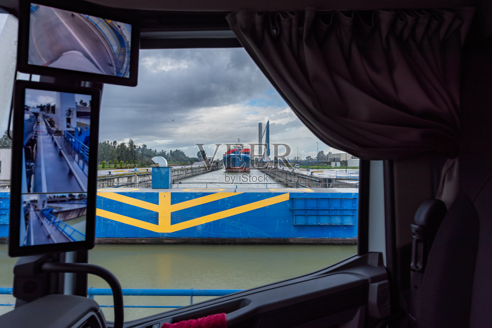 塞维利亚，瓜达尔基维尔河，一辆卡车穿过商船吊桥，从里面看过去。照片摄影图片