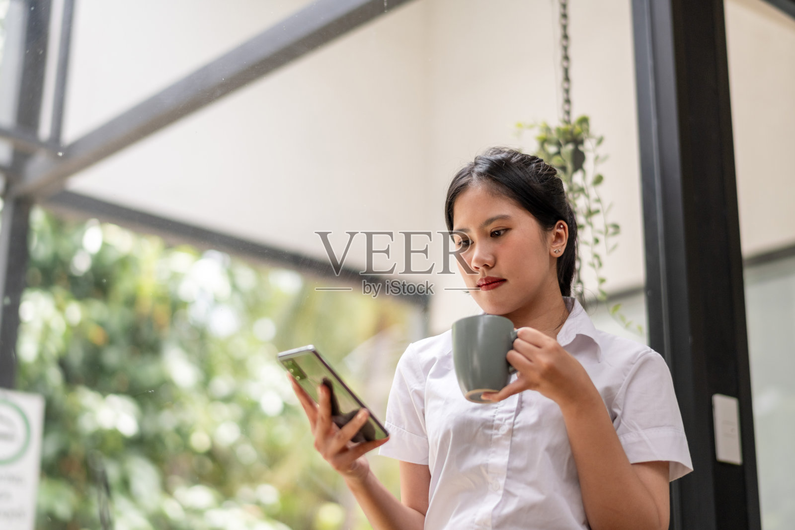 快乐的女商人在休息时喝咖啡并使用手机照片摄影图片