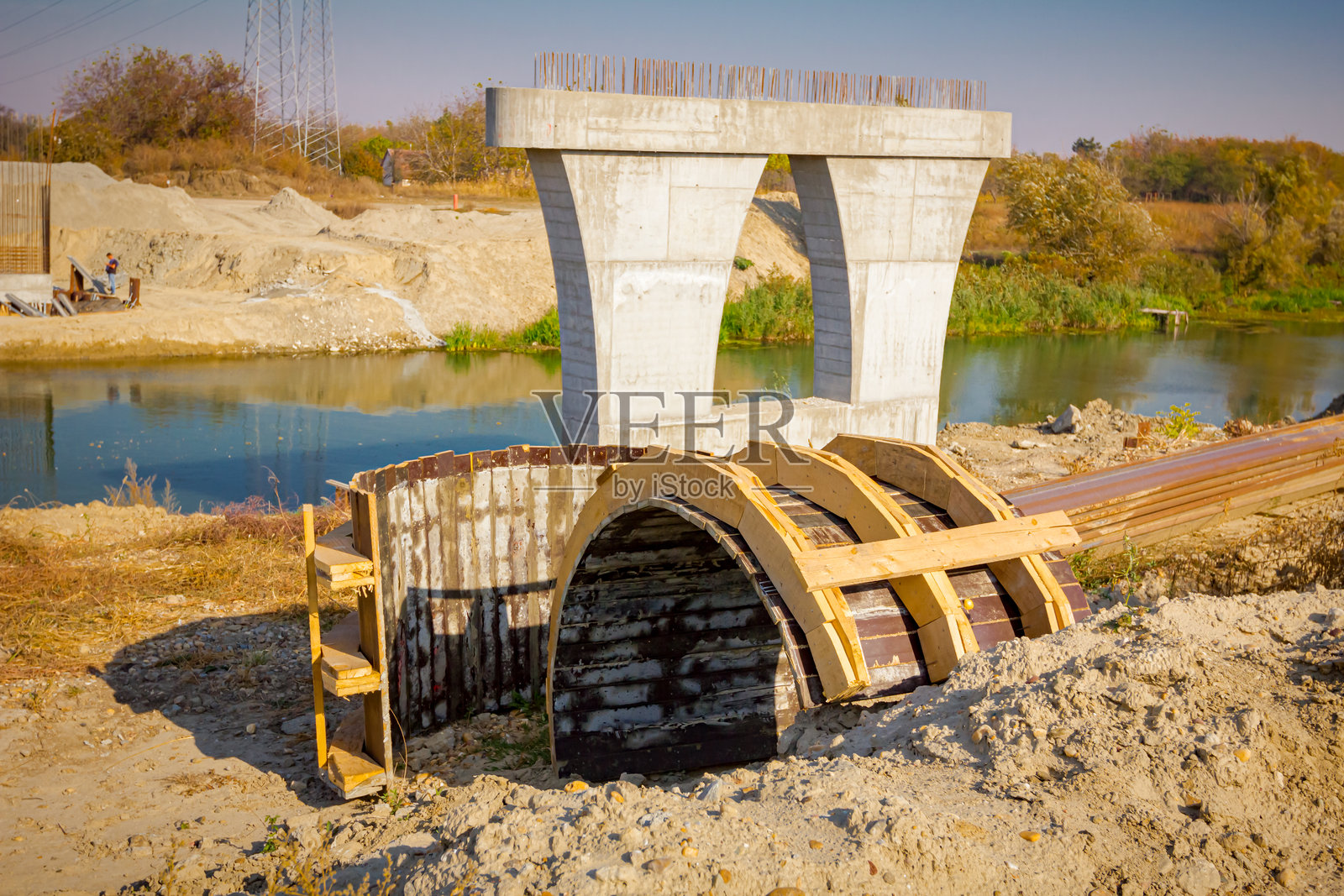 建筑工地上的木拱形模具，基础中的巨大柱子与金属桩，混凝土加固桥柱的施工照片摄影图片